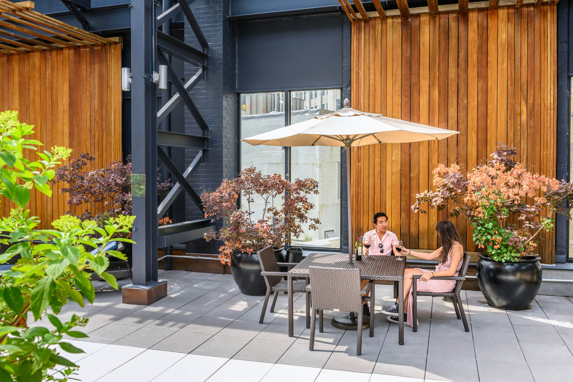 Couple sitting beneath an umbrella on rooftop lounge