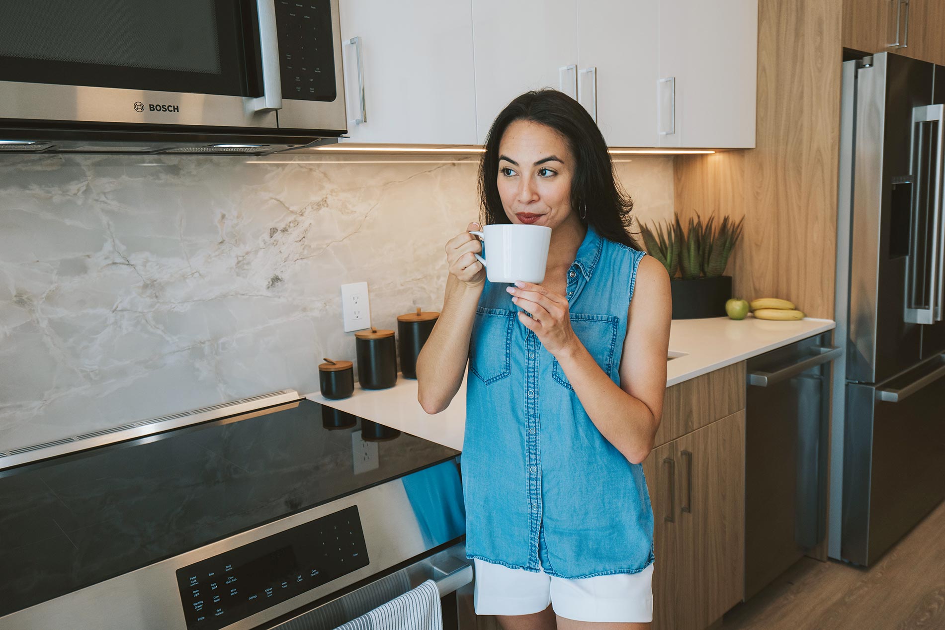 101 N Meridian woman drinks coffee in kitchen