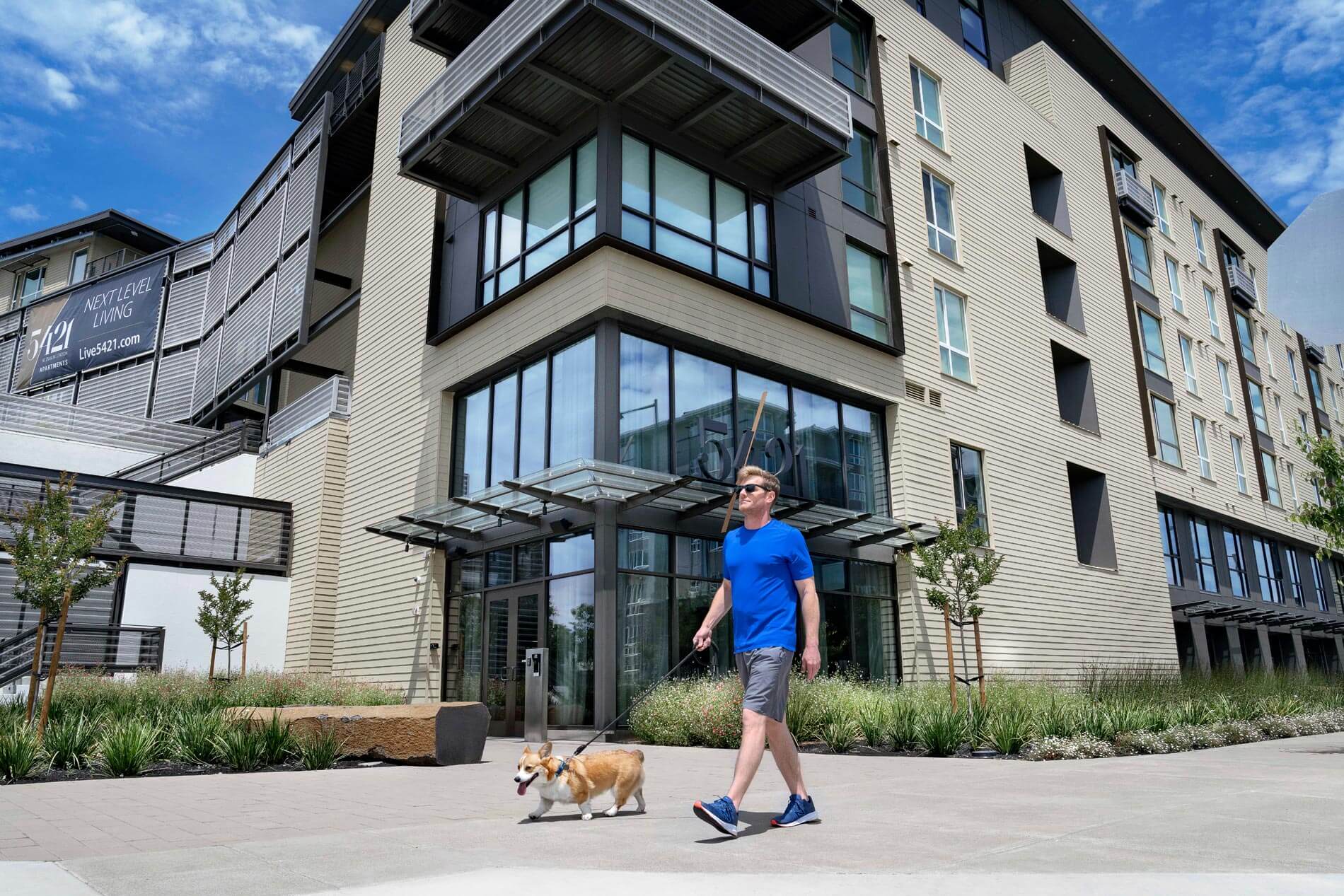 5421 Dublin man walks dog in front of building