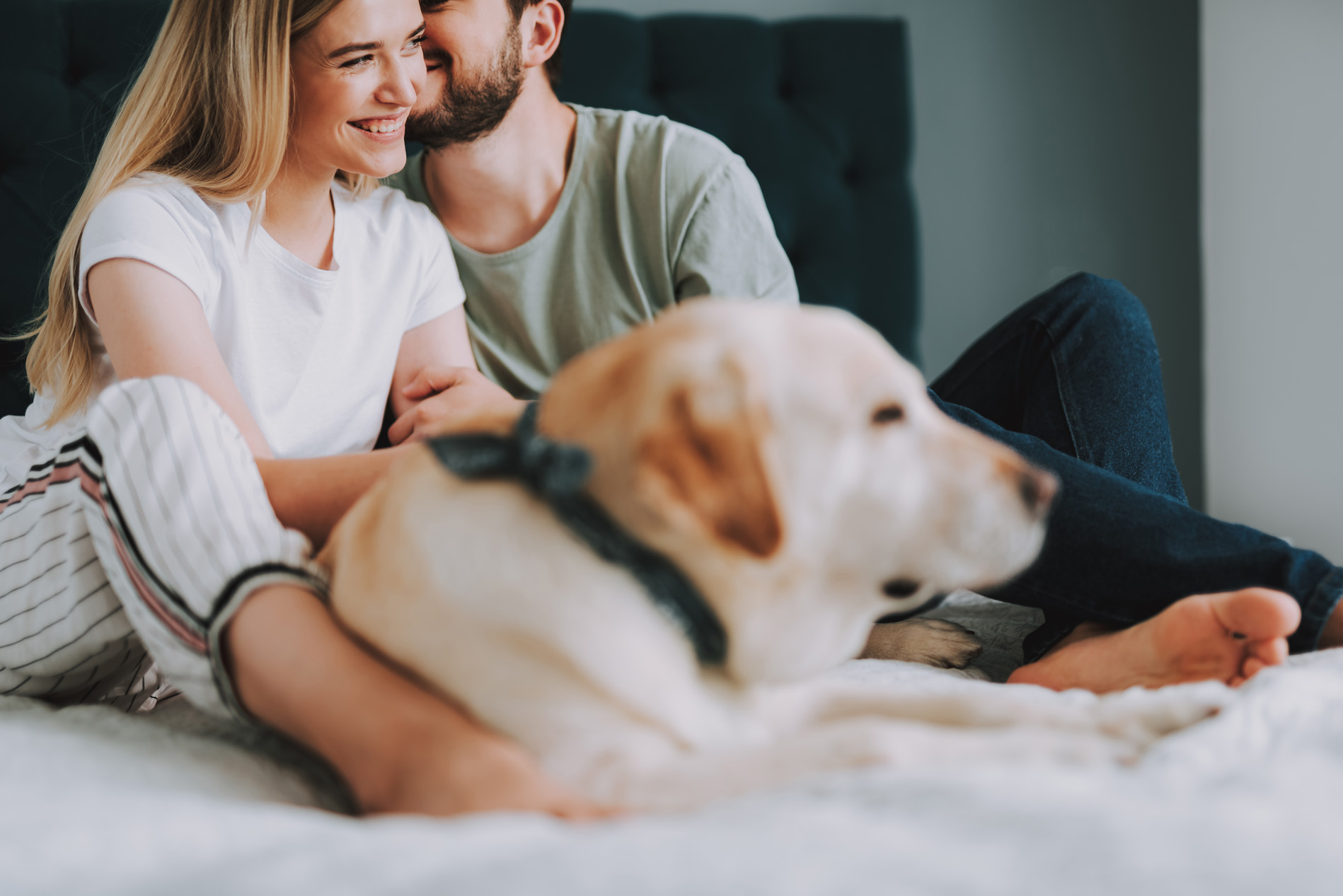 People sitting on bed with dog