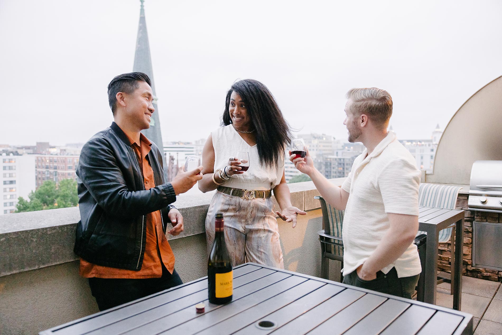 Andover House three people on roof deck with wine
