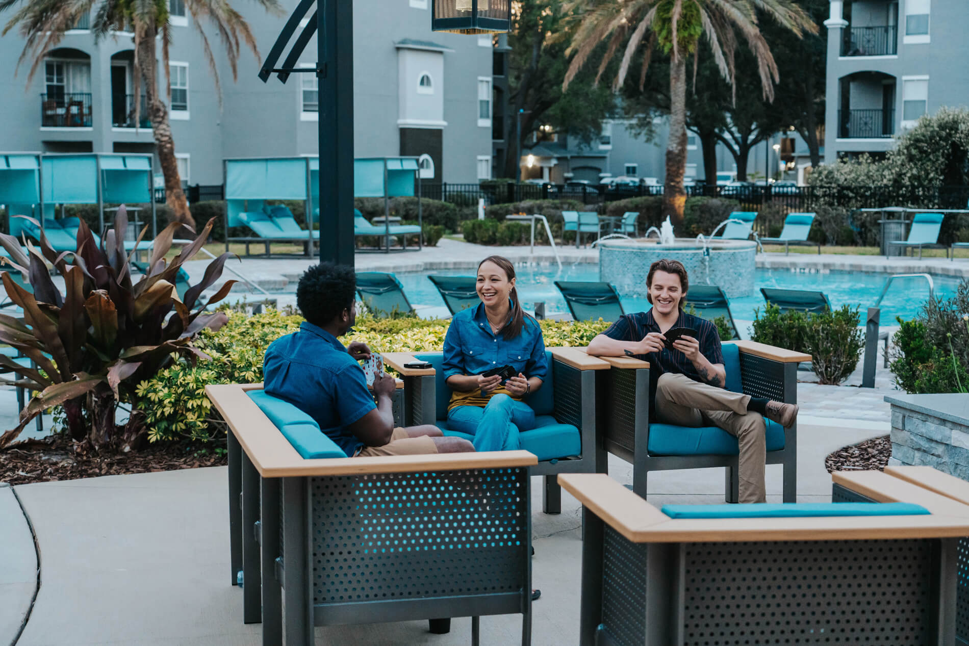 Arbors At Maitland three people sit by pool