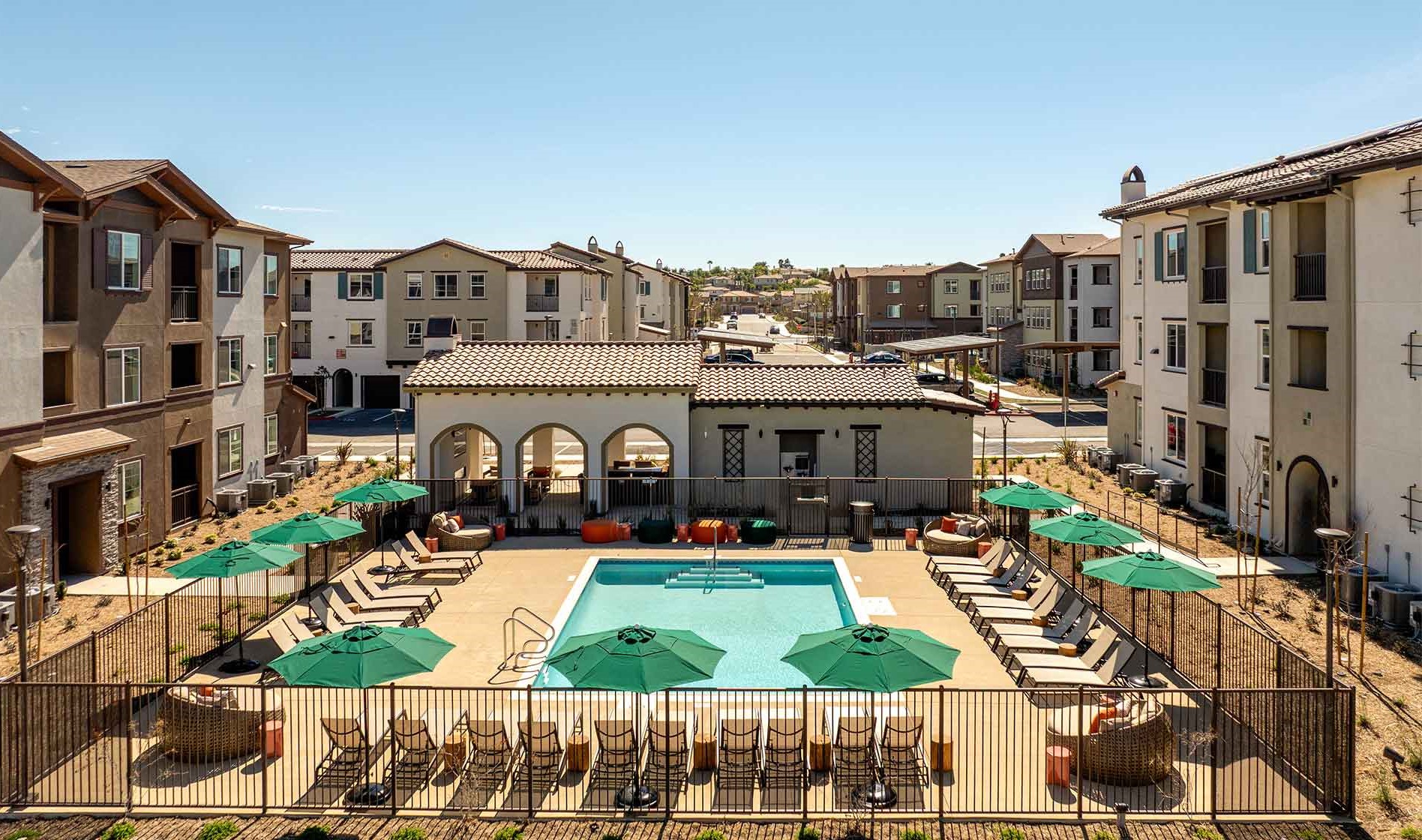 Outdoor swimming pool surrounded by apartment homes at Avena in Menifee, CA