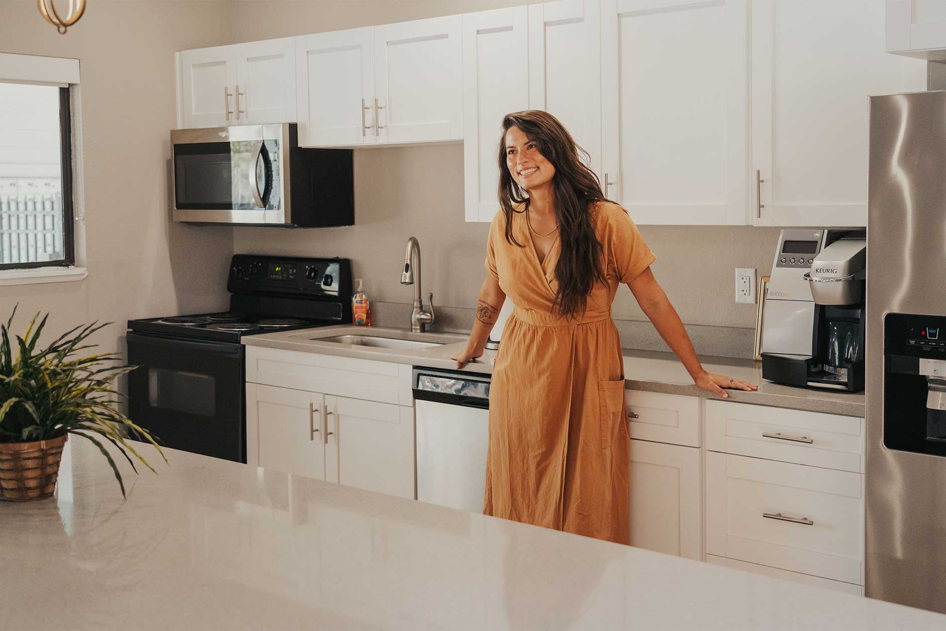 Woman preparing a meal in a modern kitchen at Avena apartments in Menifee, CA