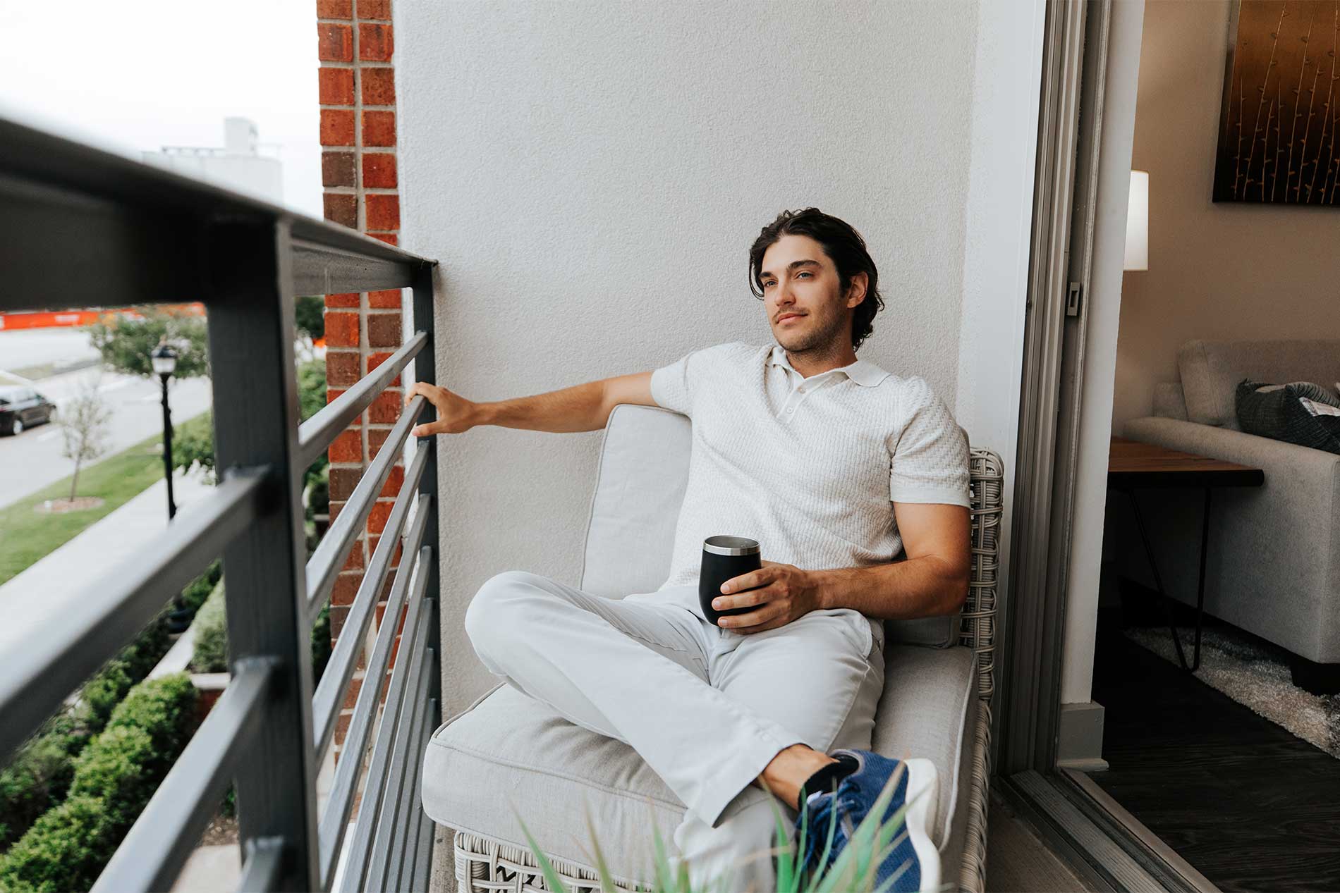 Man enjoying outdoor seating on an apartment patio at Avena in Menifee