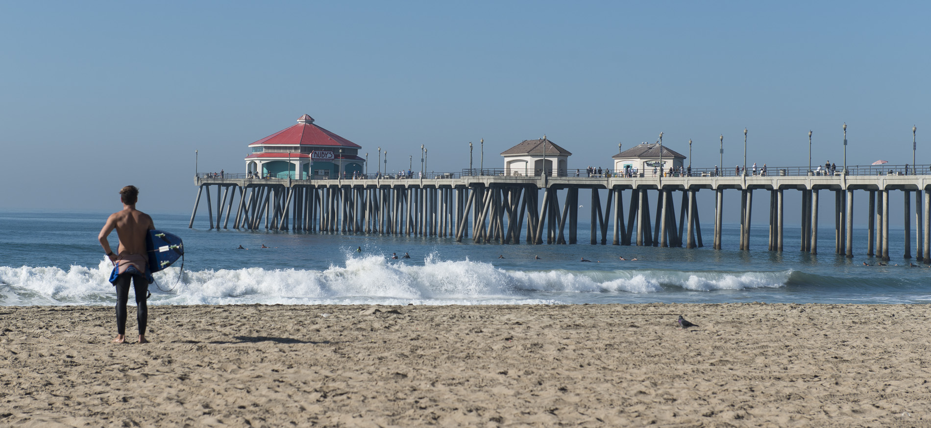 Man stands by the beach pier