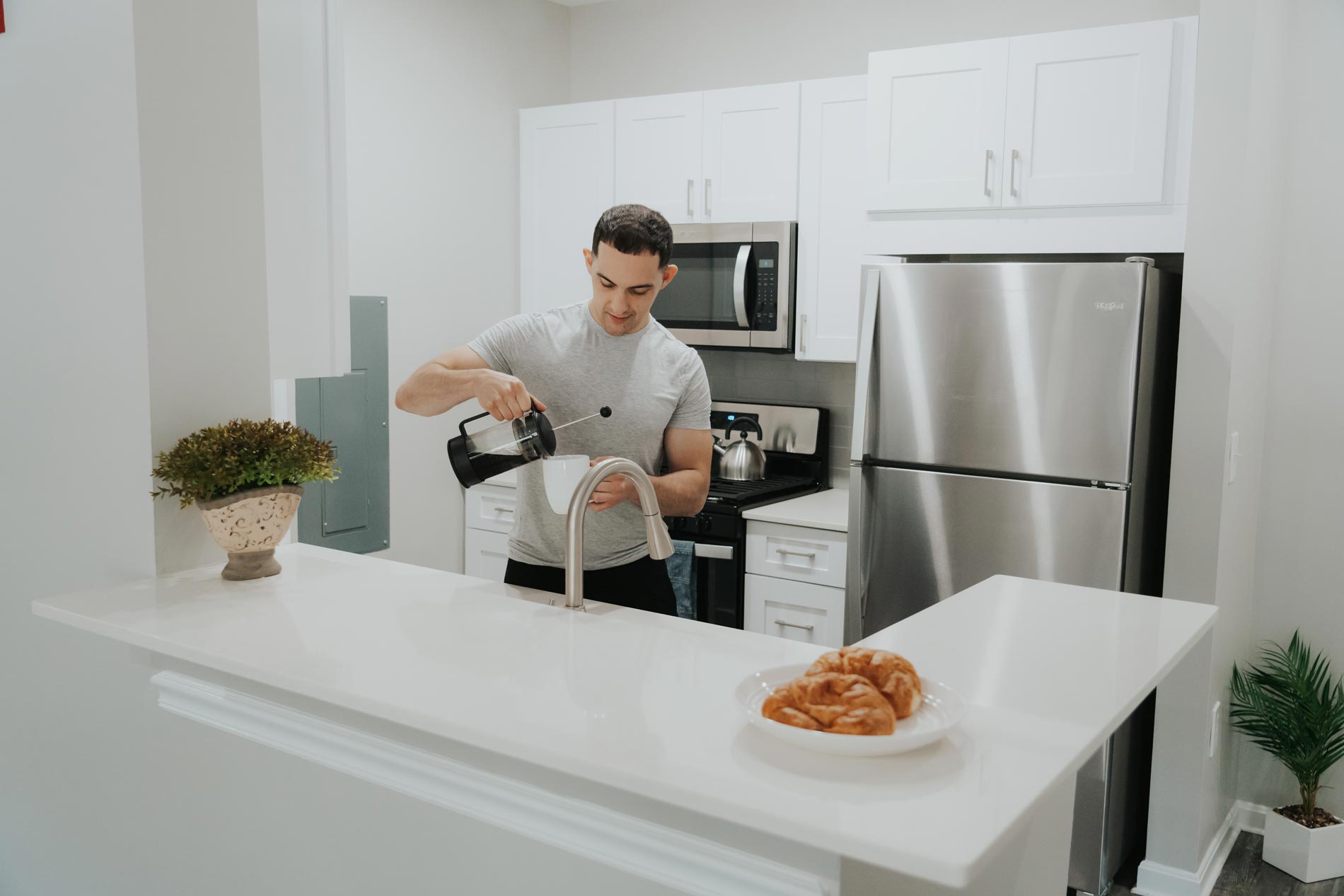 Bradlee Danvers man pours coffee in kitchen