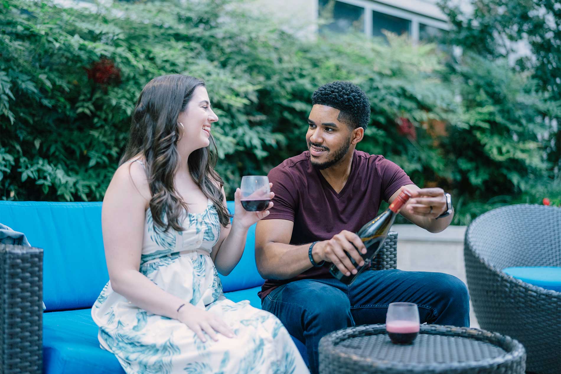 Young man and woman sitting outside enjoying wine