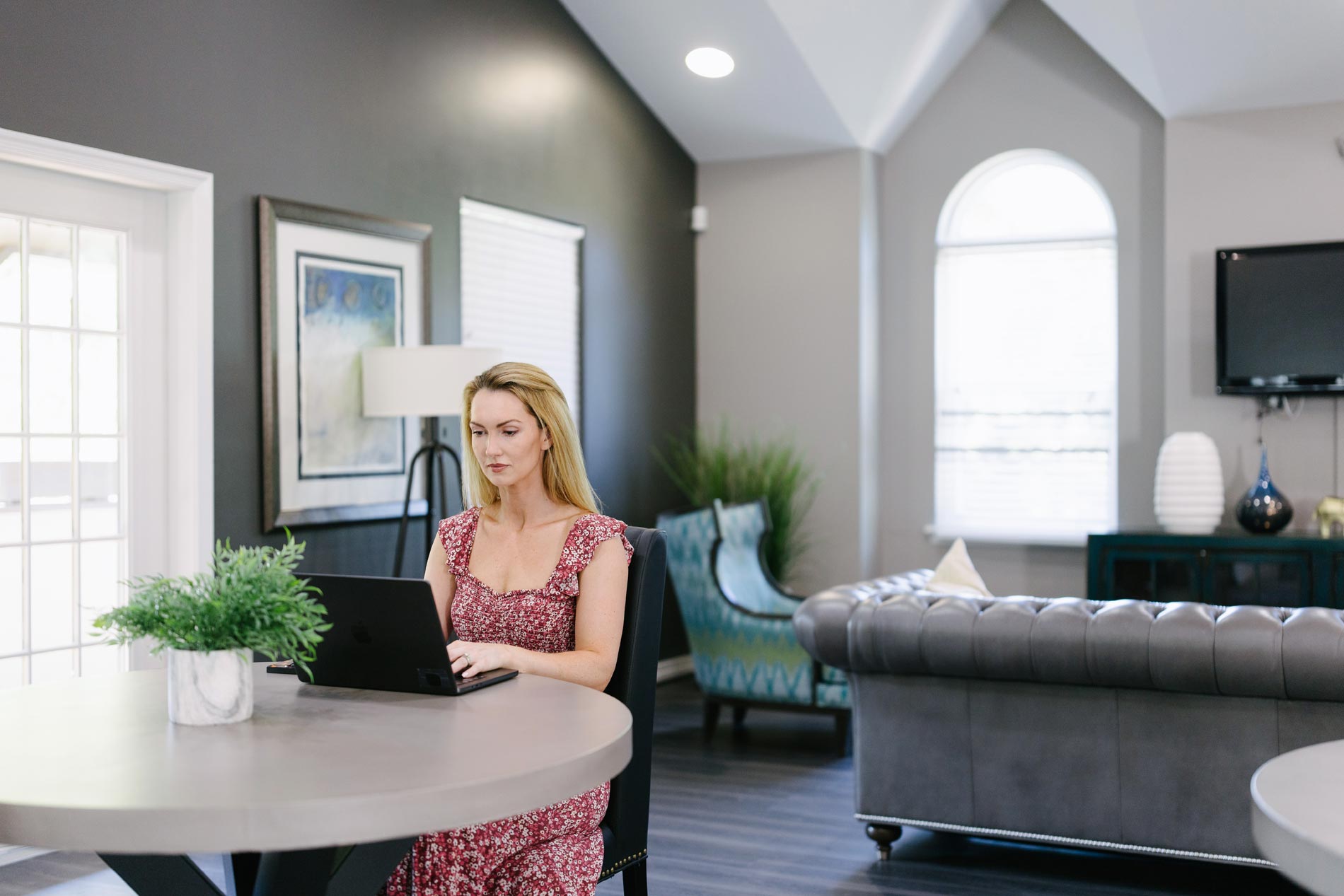 Calverts Walk woman works on laptop in clubhouse