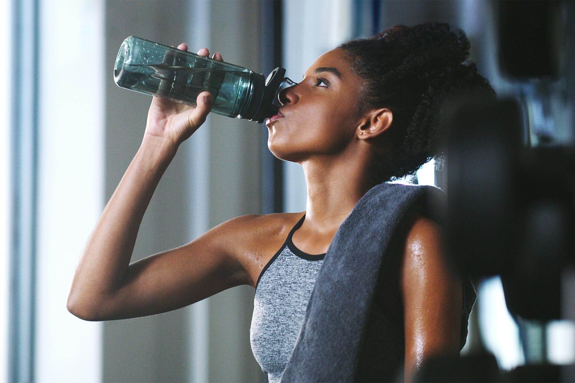 Woman in fitness center drinking water