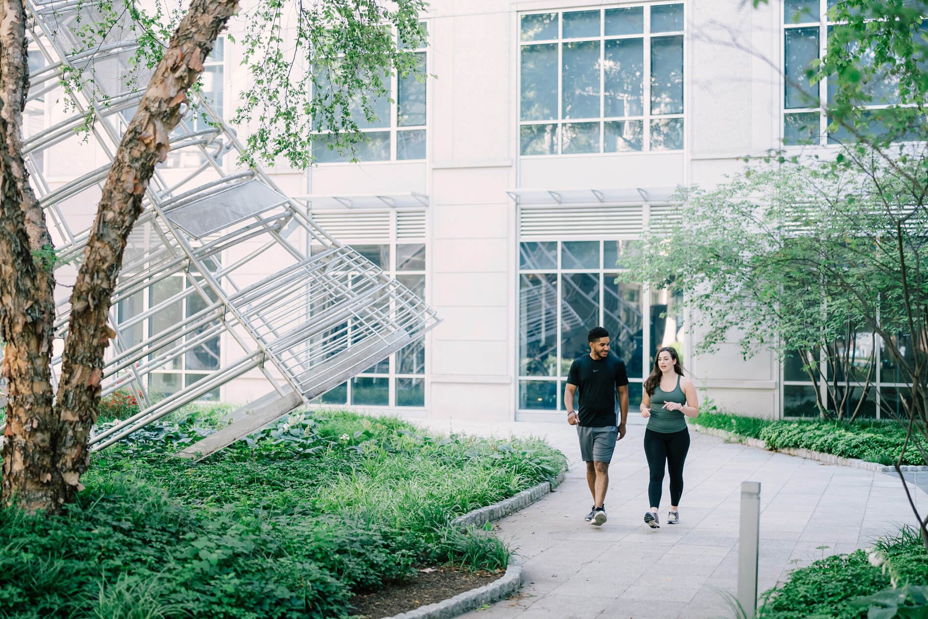 Domus Apartments man and woman walking in front of property