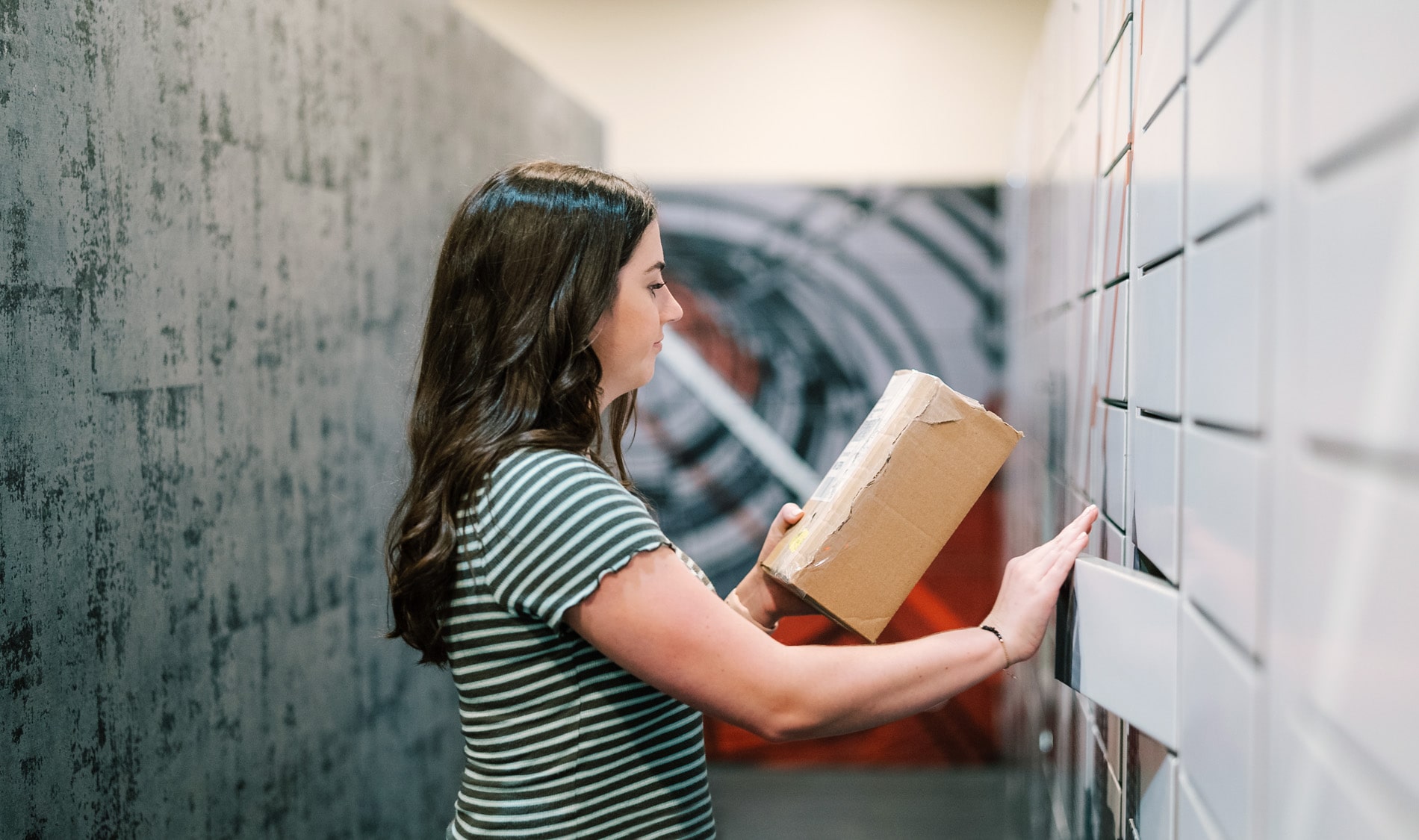 Domus Apartments woman getting package from lockers