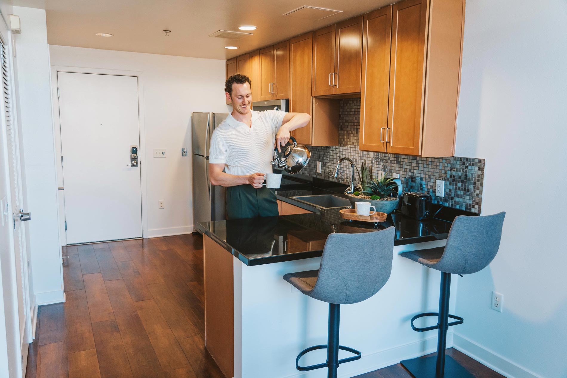 Edgewater man pours coffee in staged kitchen