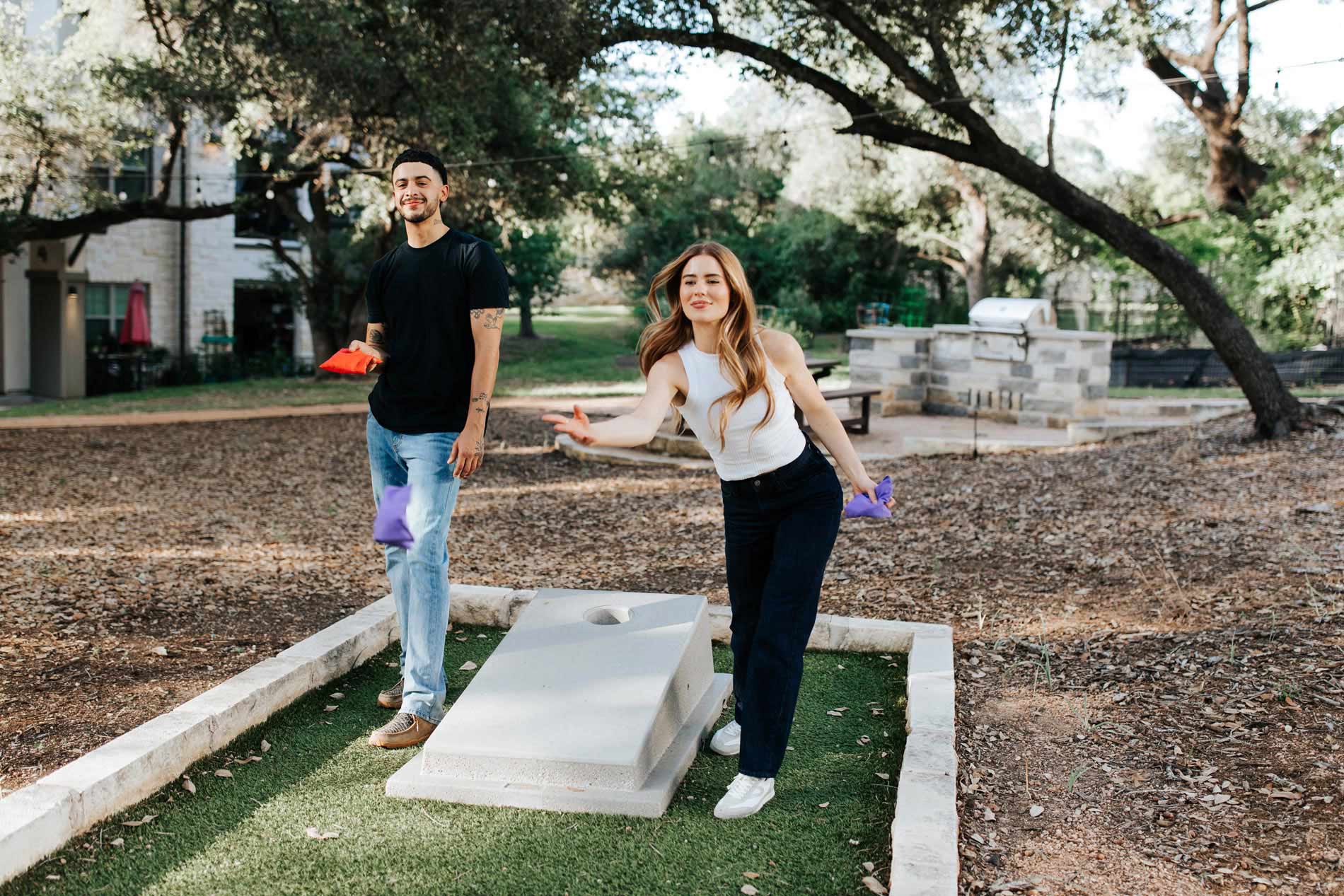 Estancia Villas woman and man play corn hole