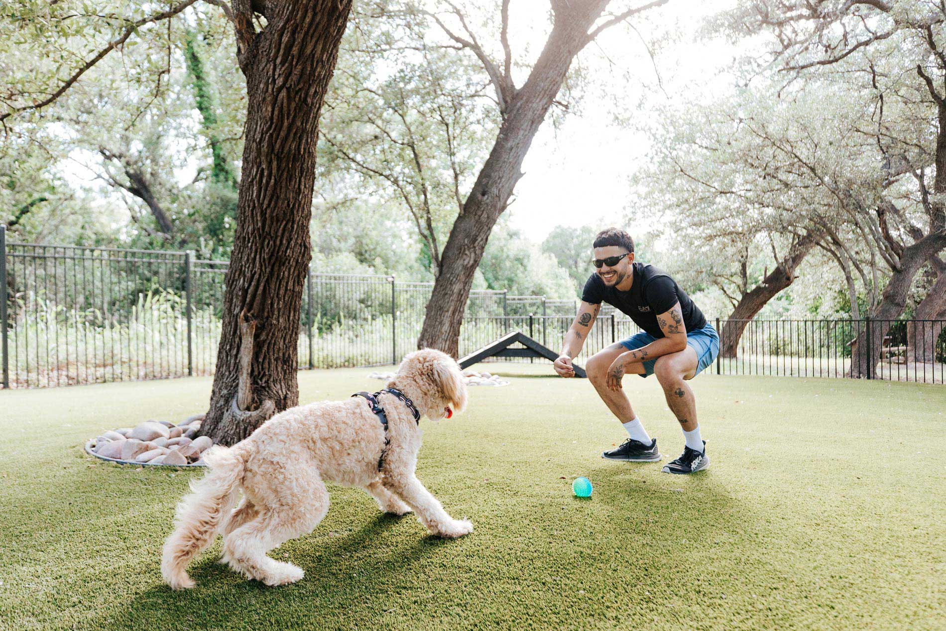 Estancia Villas man plays with dog in dog park