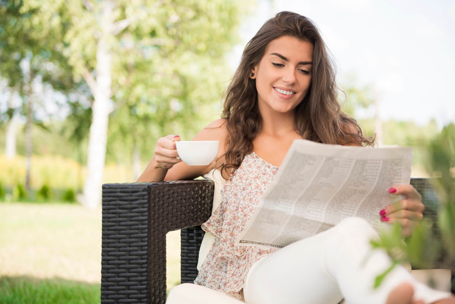 Woman sitting outside looking at the paper