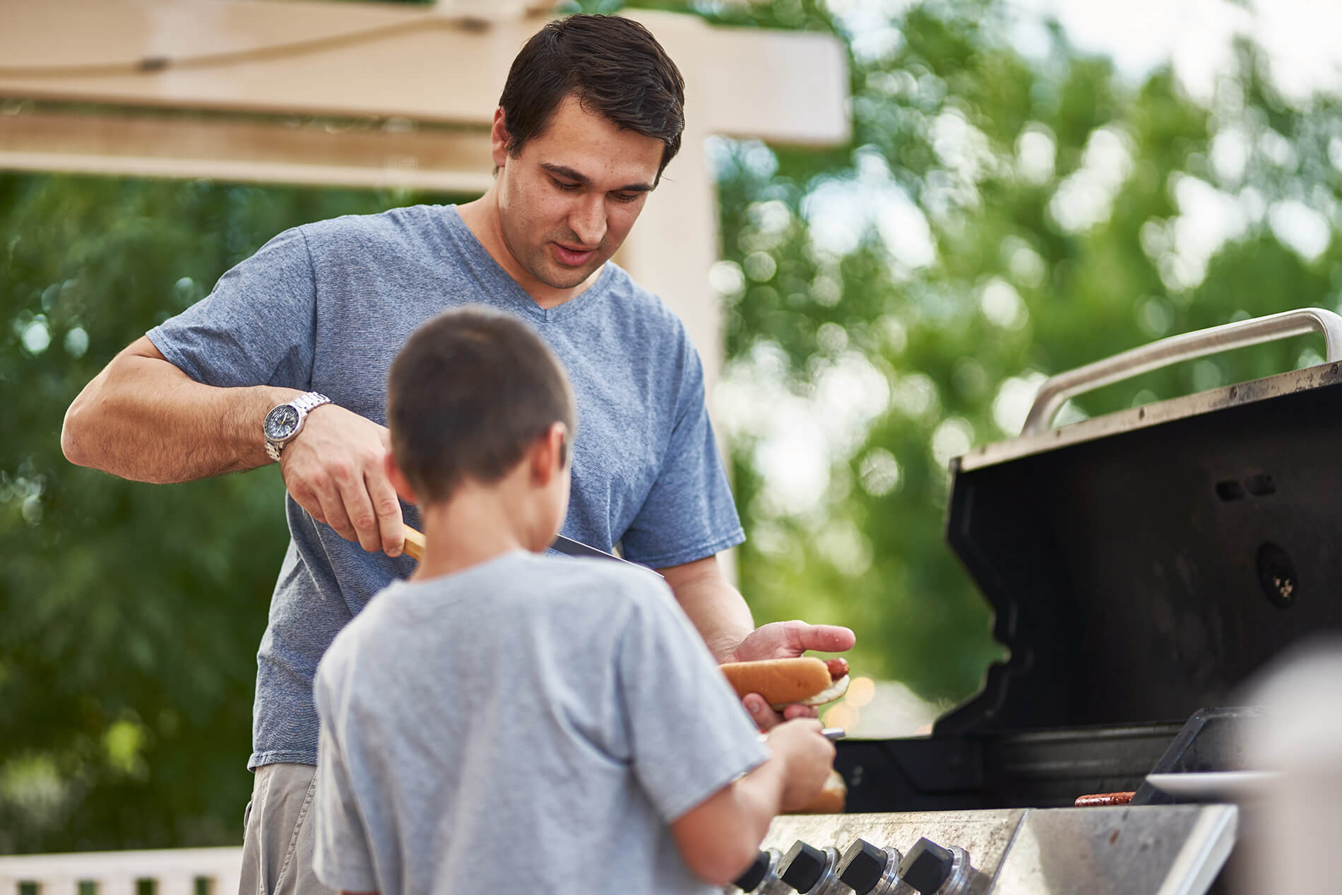 People cooking at the outdoor grill