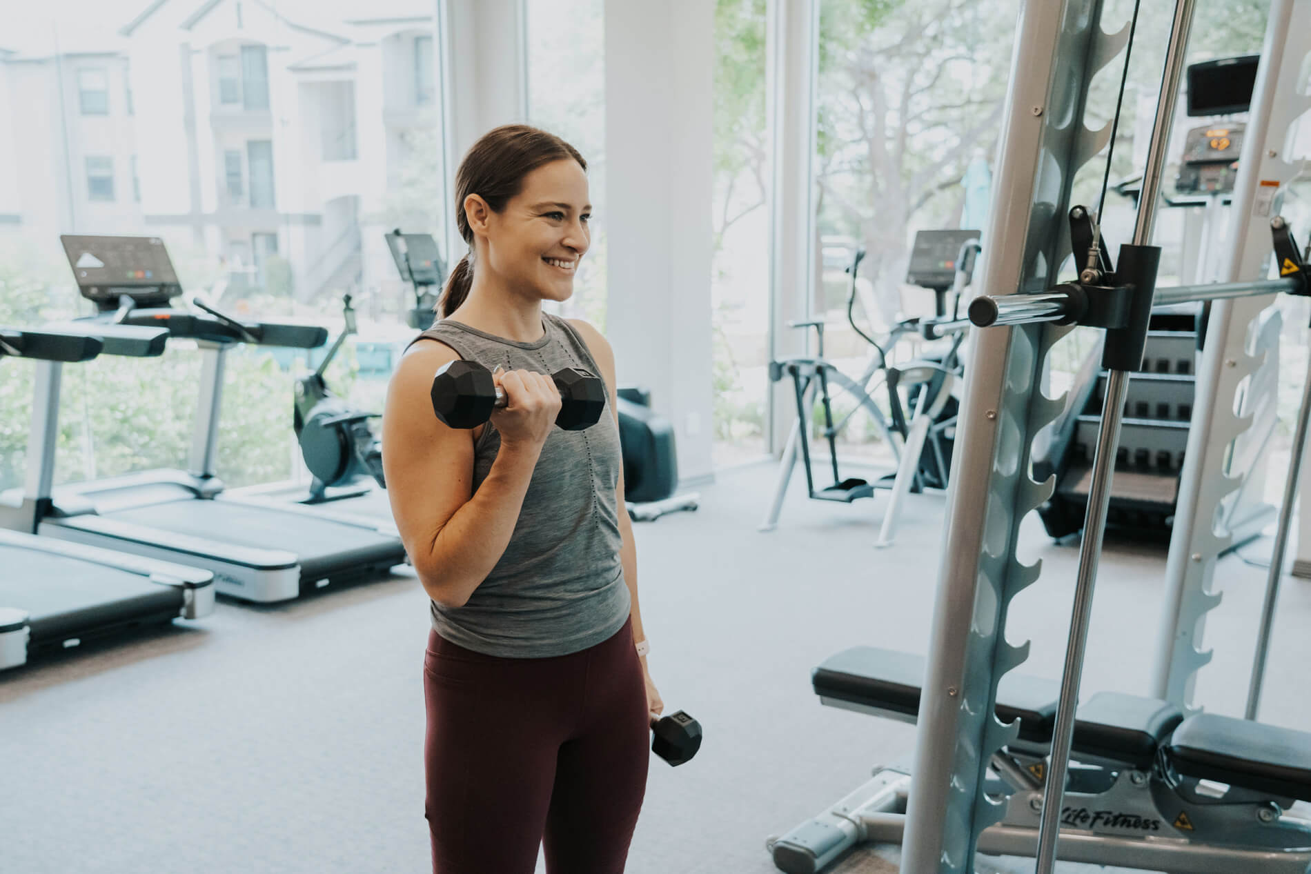 Lakeline Villas woman lifts weights in fitness center