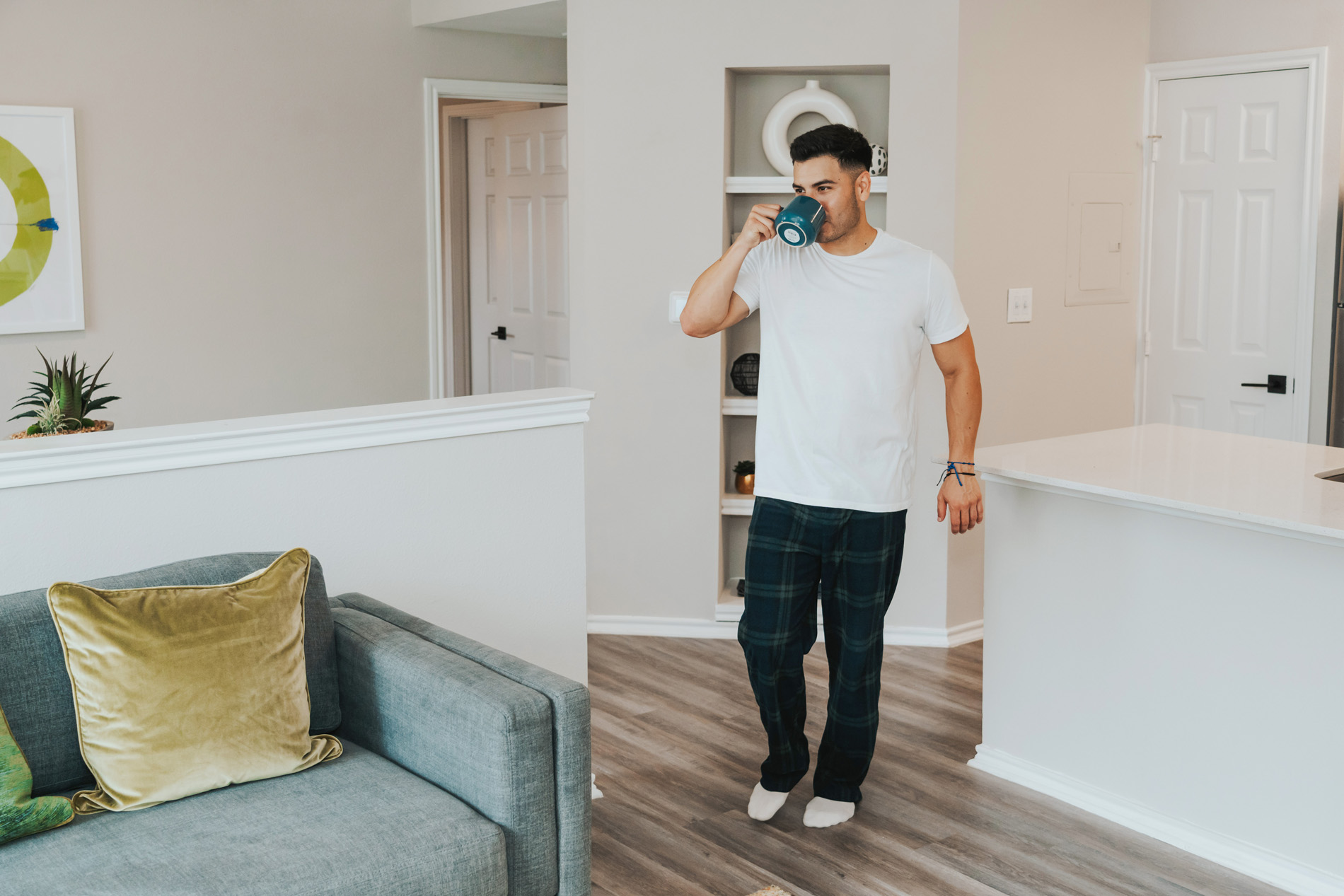 Lakeline Villas man drinks coffee walking to living room