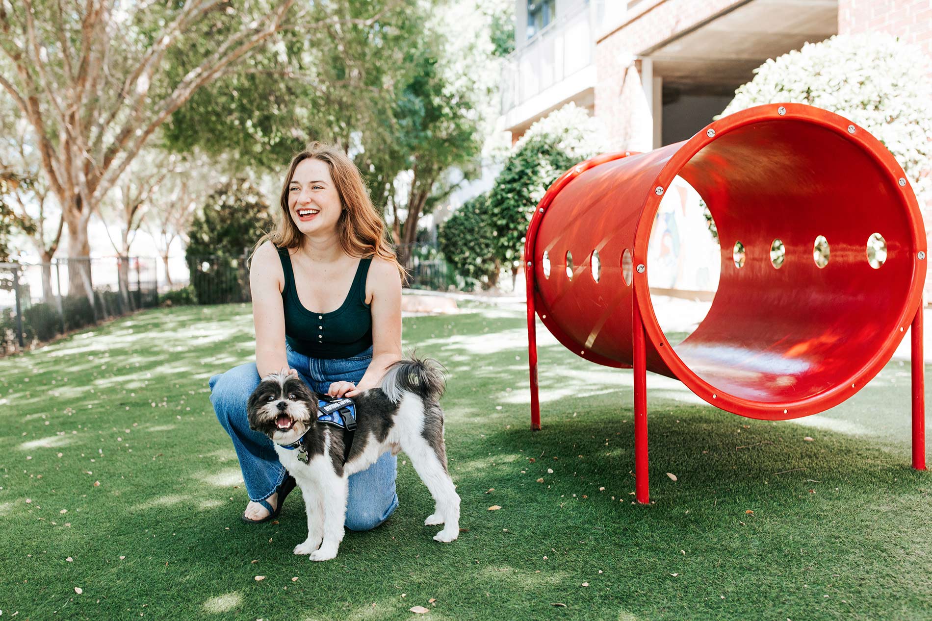 Legacy Village woman plays with dog in dog park