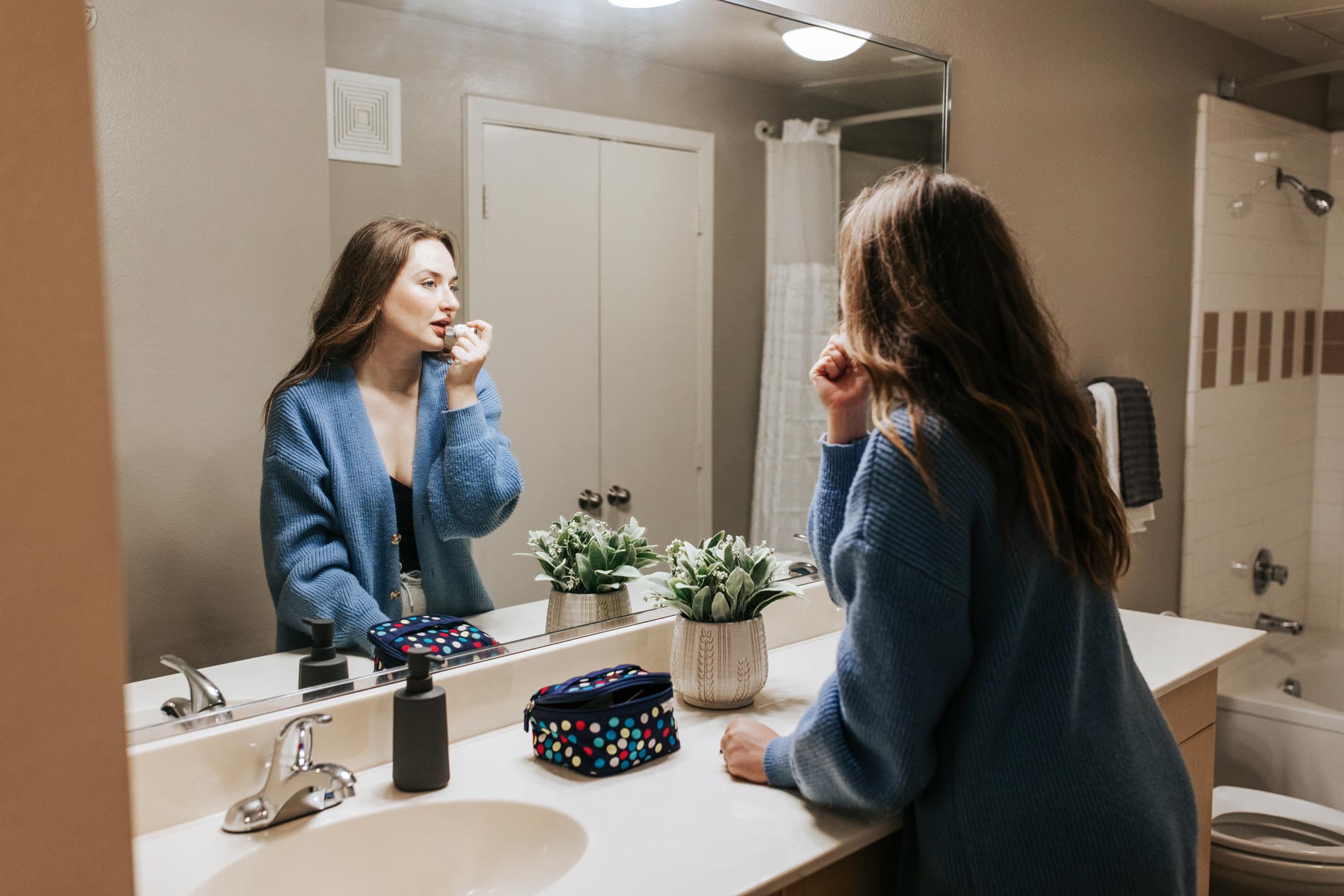 Legacy Village woman gets ready in apartment bathroom
