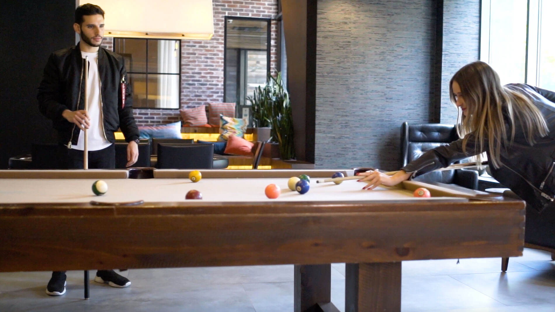 People playing billiards in the Leonard Pointe clubroom