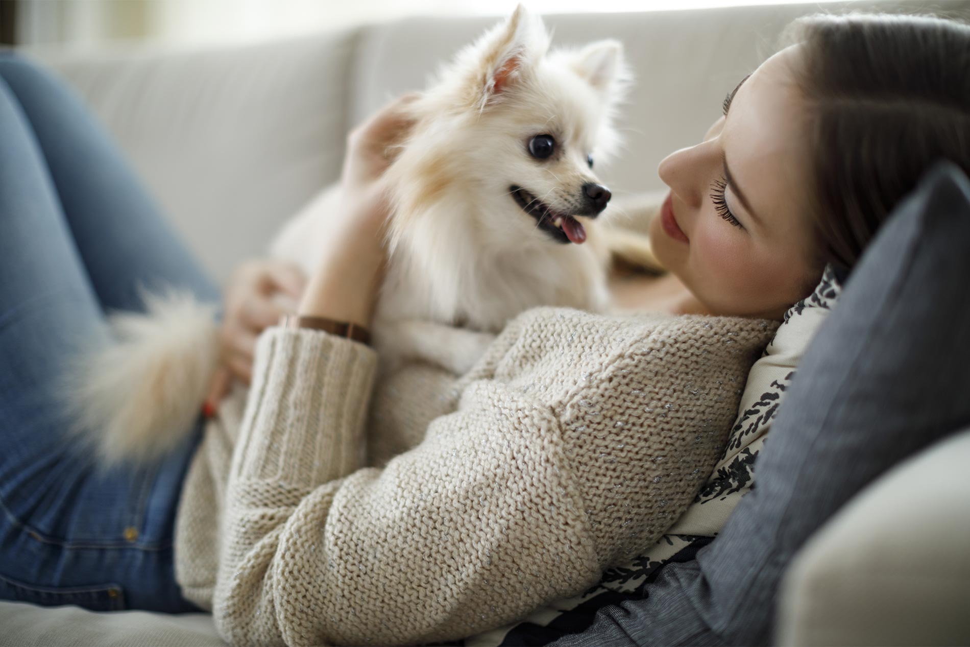 Woman on couch with a happy dog