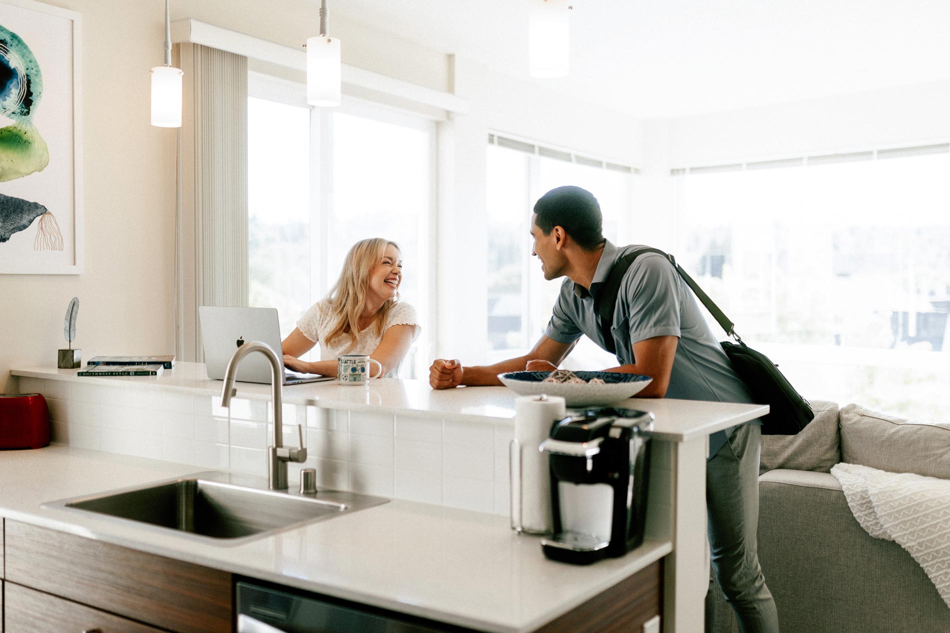 Milehouse woman and man at kitchen counter laugh