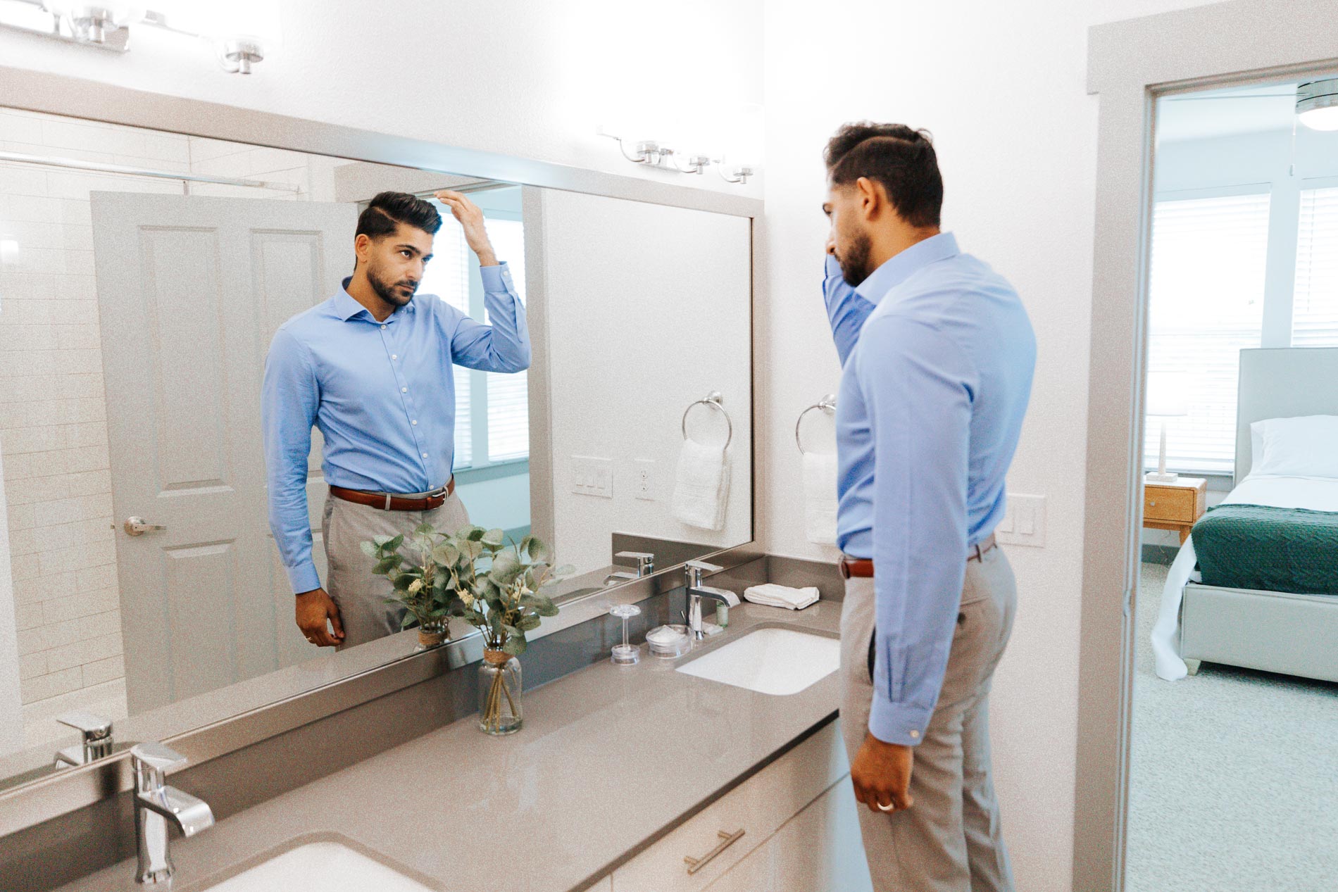Palo Verde man fixes his hair in the bathroom