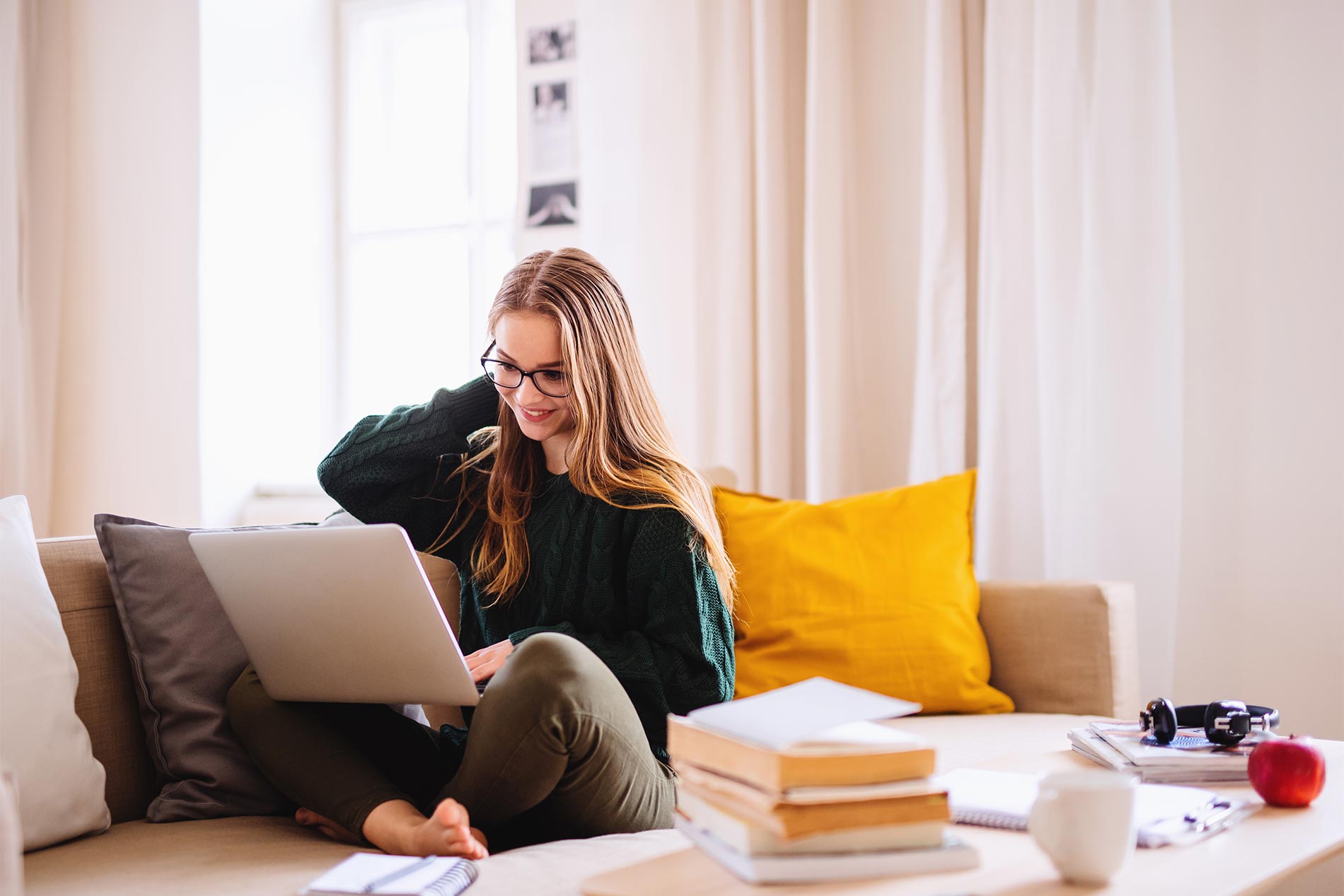 Young woman sitting on couch with laptop