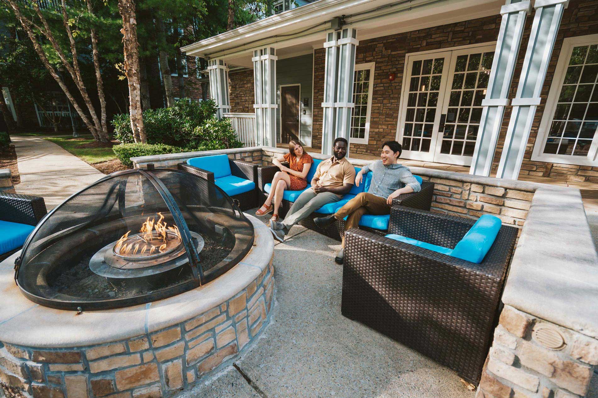 Ridge at Blue Hills three people by fire pit 