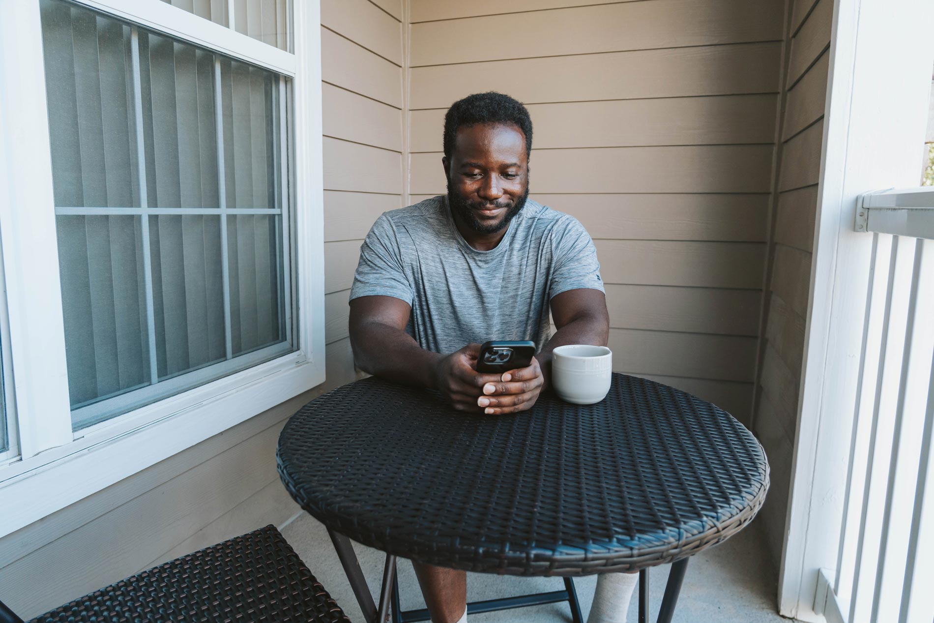 Ridge at Blue Hills man sits on apartment patio