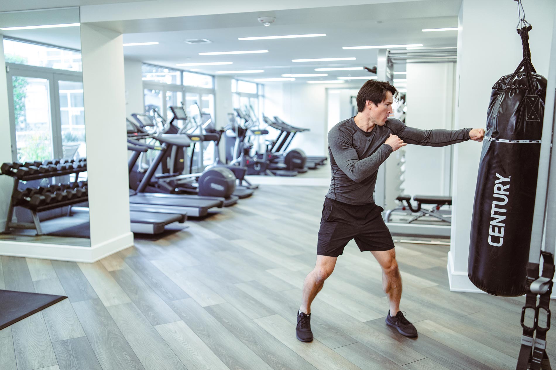 Strata man punches punching bag in fitness center