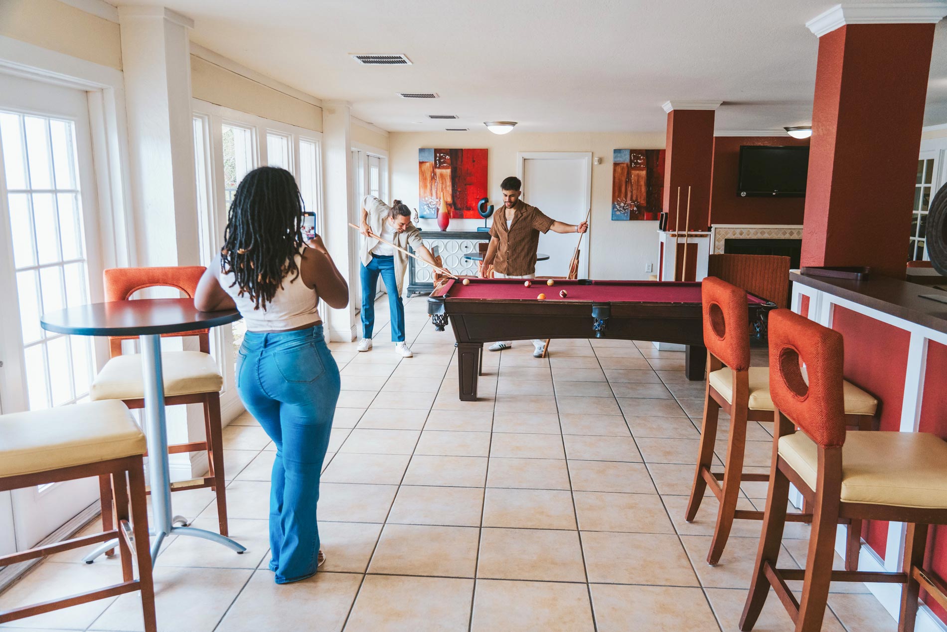 The Breyley three people play pool in the clubhouse The Breyley three people play pool in the clubhouse