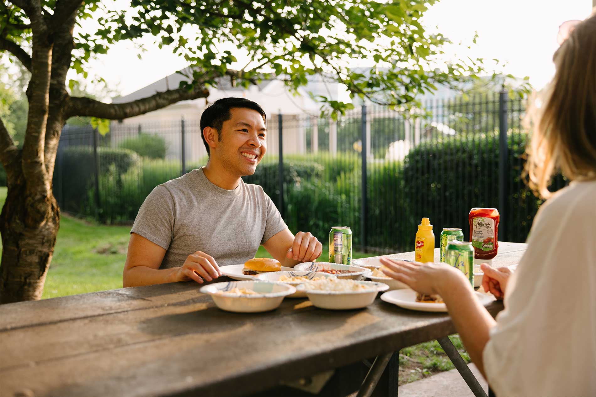 Young man eating outside by the grill