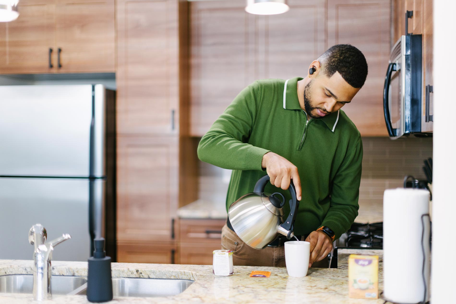 The Enclave man pours tea in the kitchen