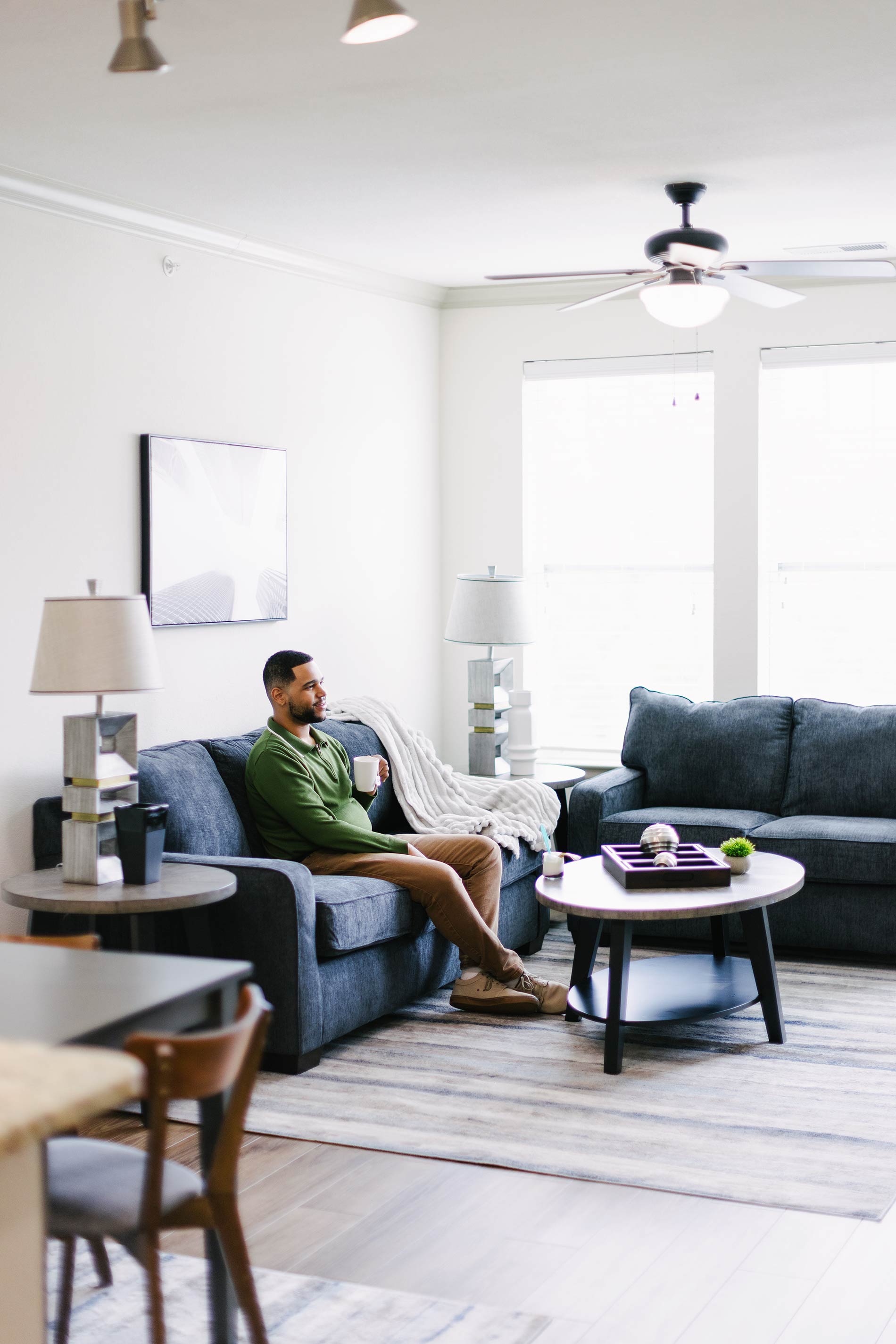 The Enclave man drinks tea in a staged living room