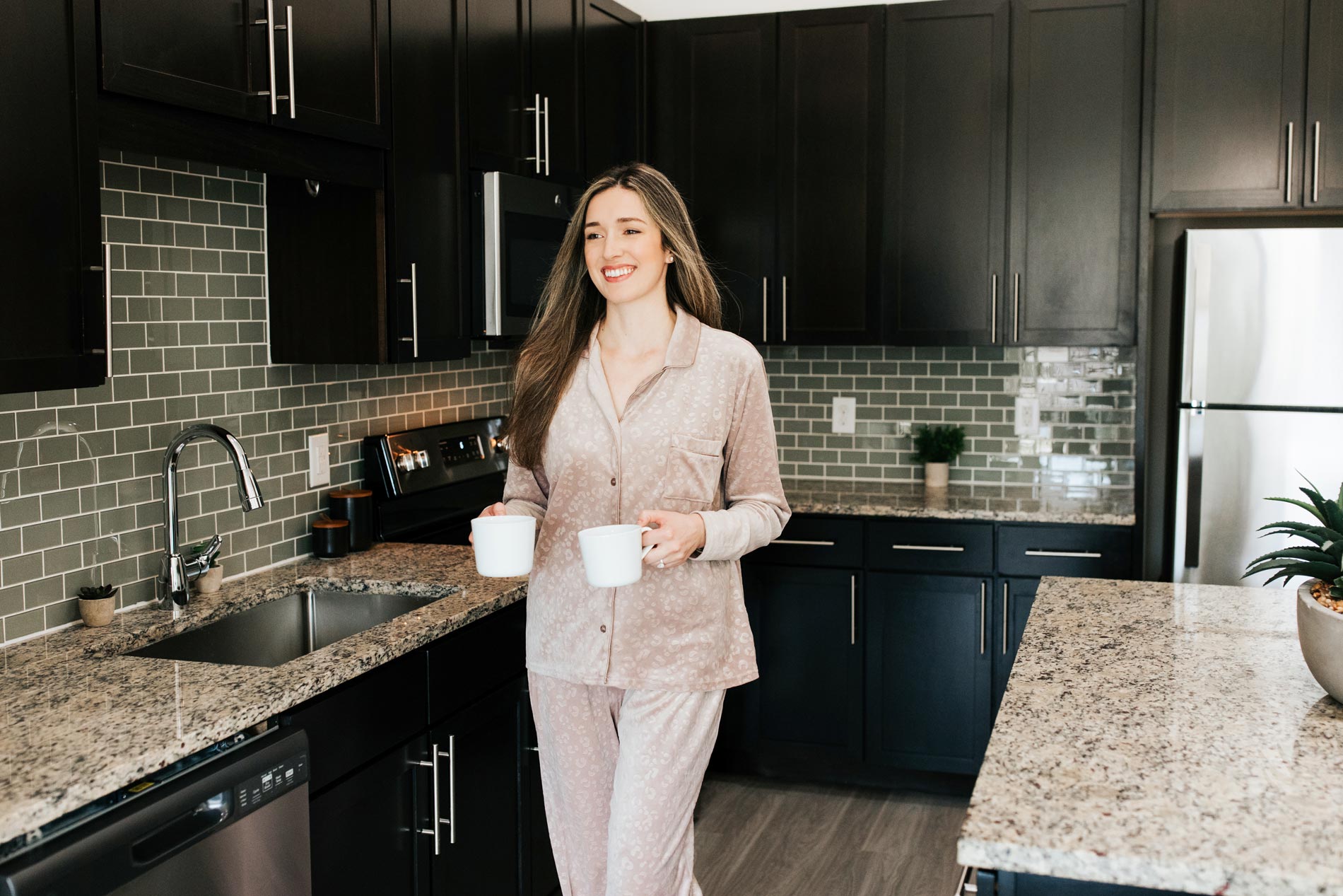 Flats At Palisades woman walks in kitchen with coffee