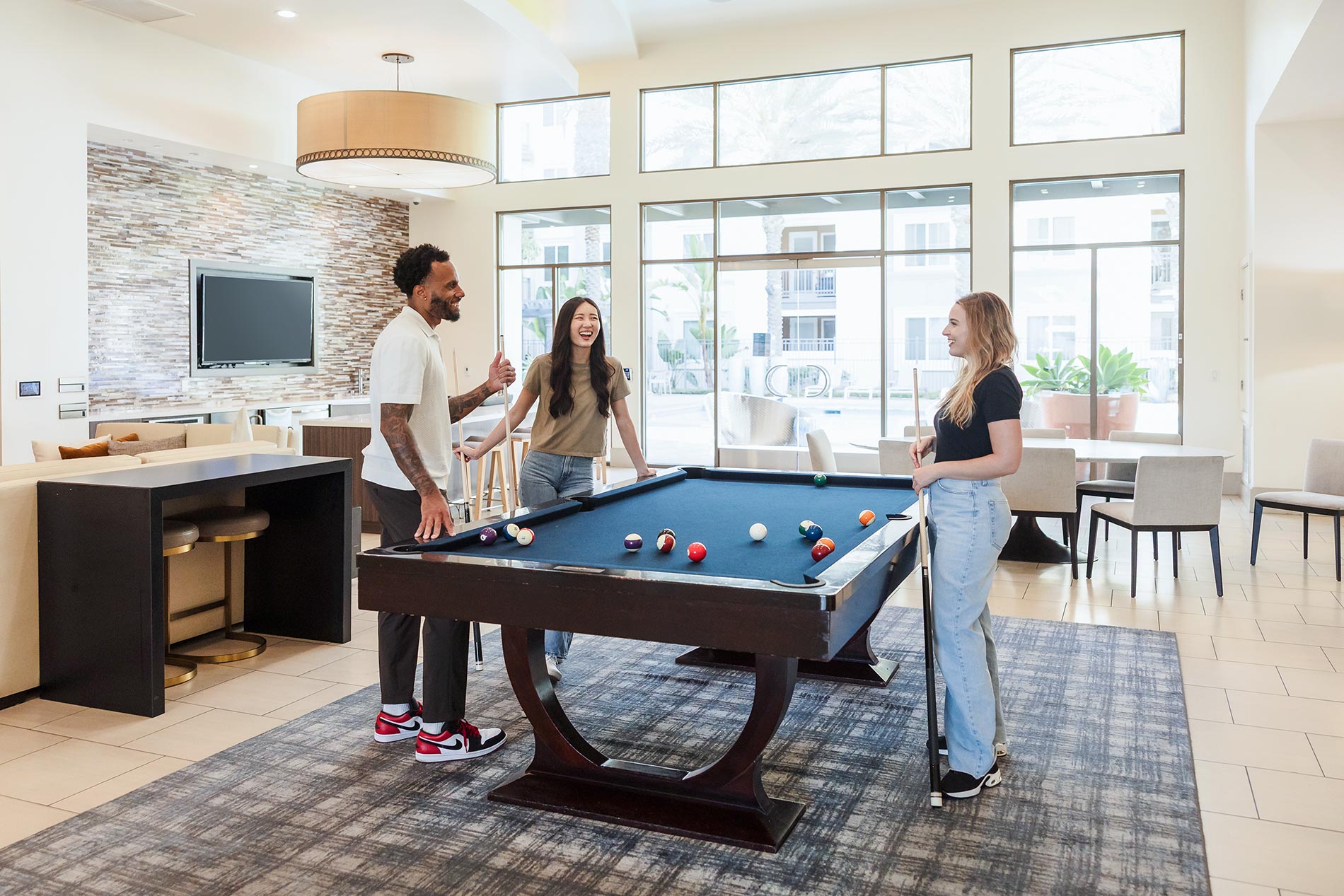 The Residences At Bella Terra three people play a game of pool