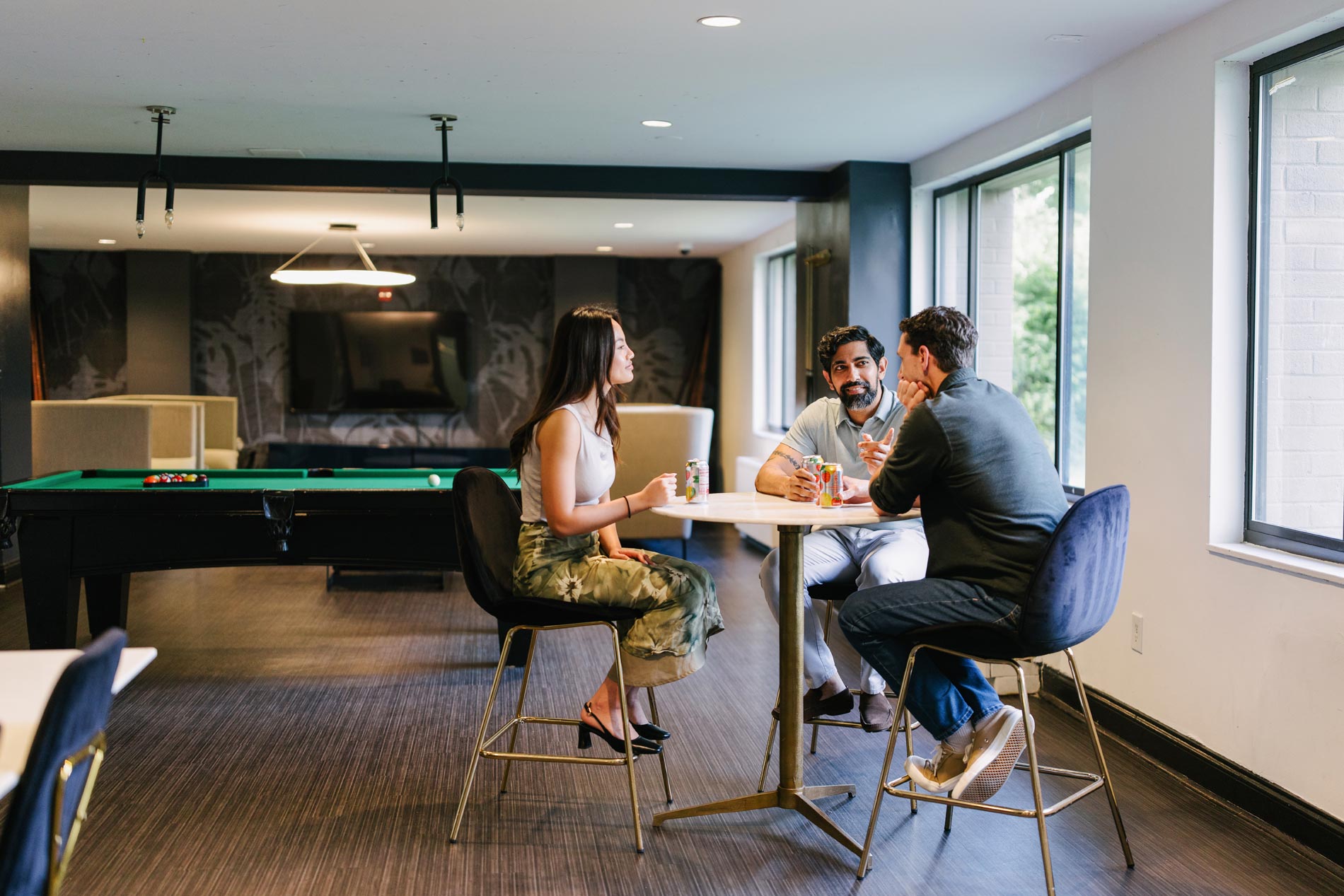 Whitmore apartments three people sit in clubhouse