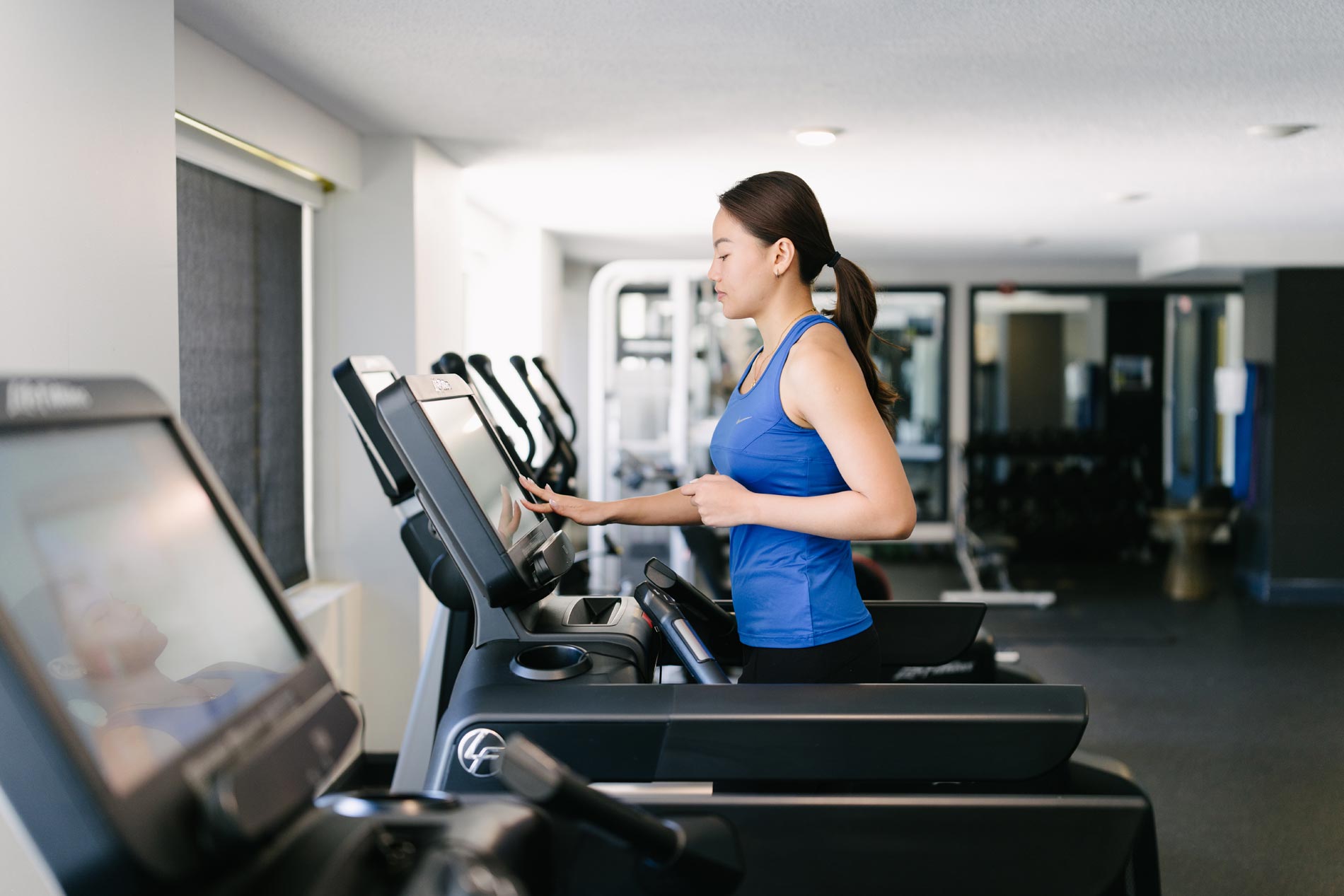 Whitmore apartments woman runs on treadmill in gym