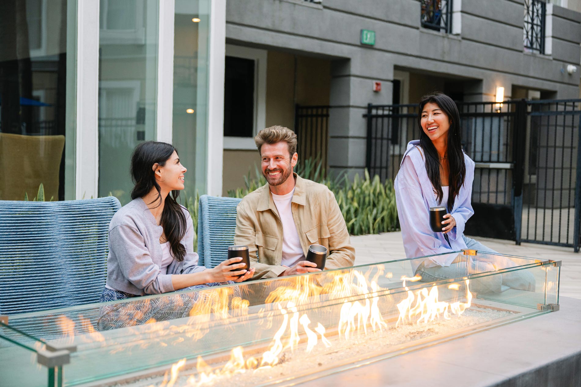 Tierra Del Rey three people sit by the fire pit