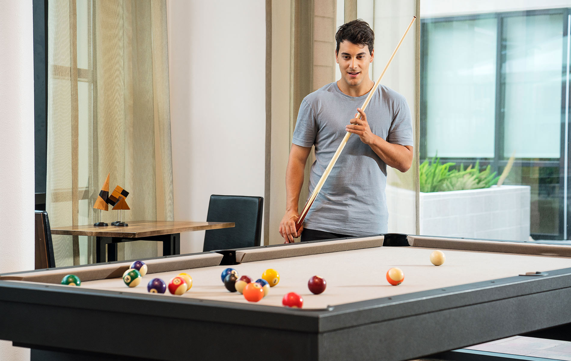 Verve man plays pool in clubhouse