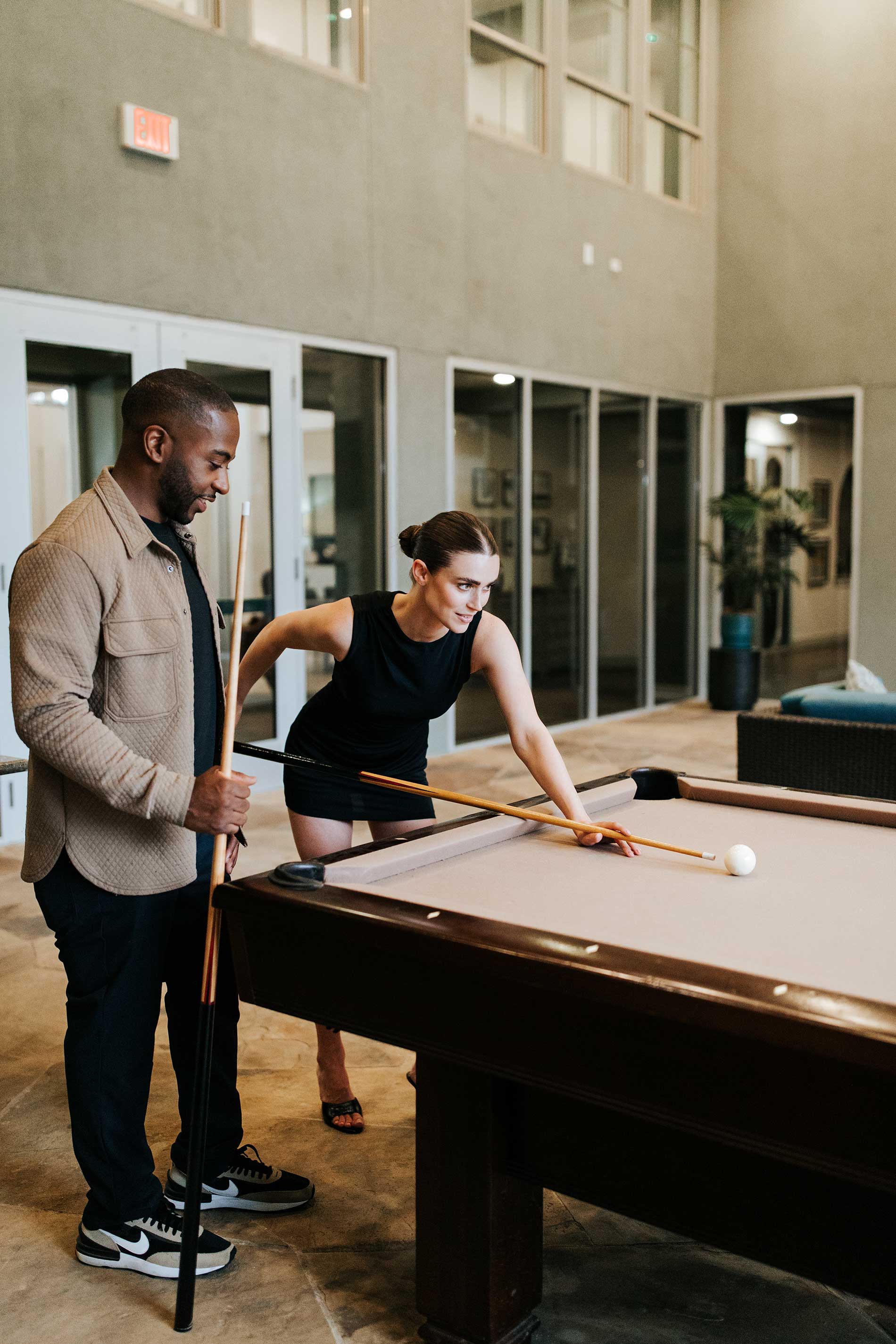 Villaggio man and woman play pool in the clubhouse