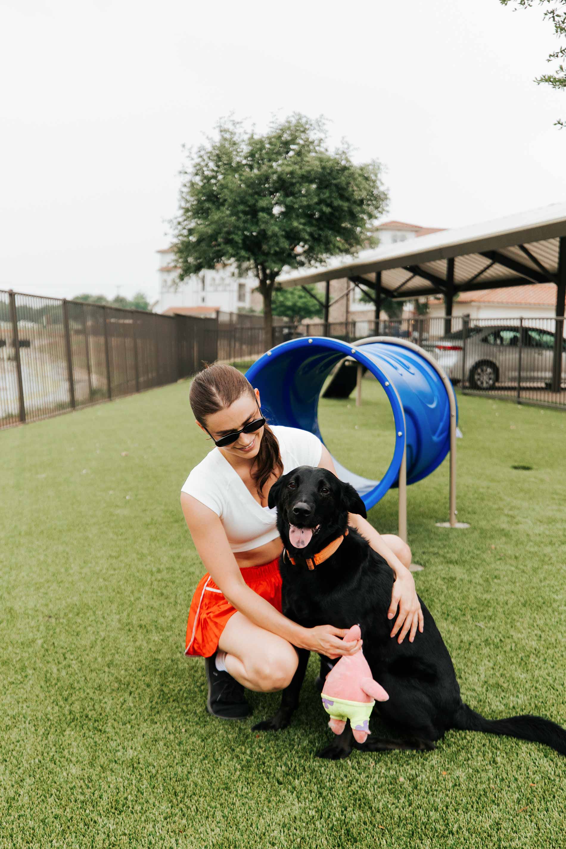 Villaggio woman plays with dog in dog park