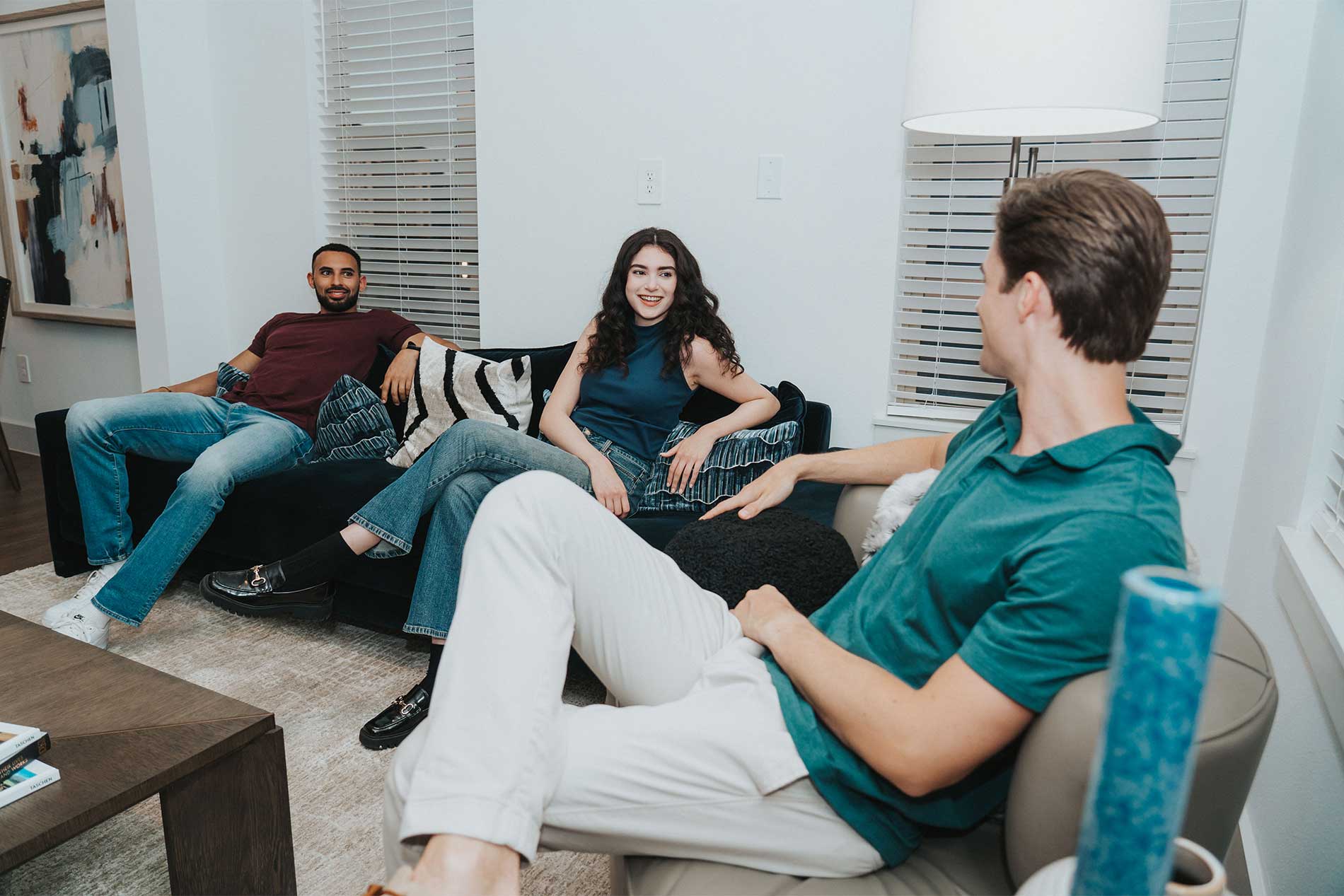 Two men and one woman sitting in apartment interior