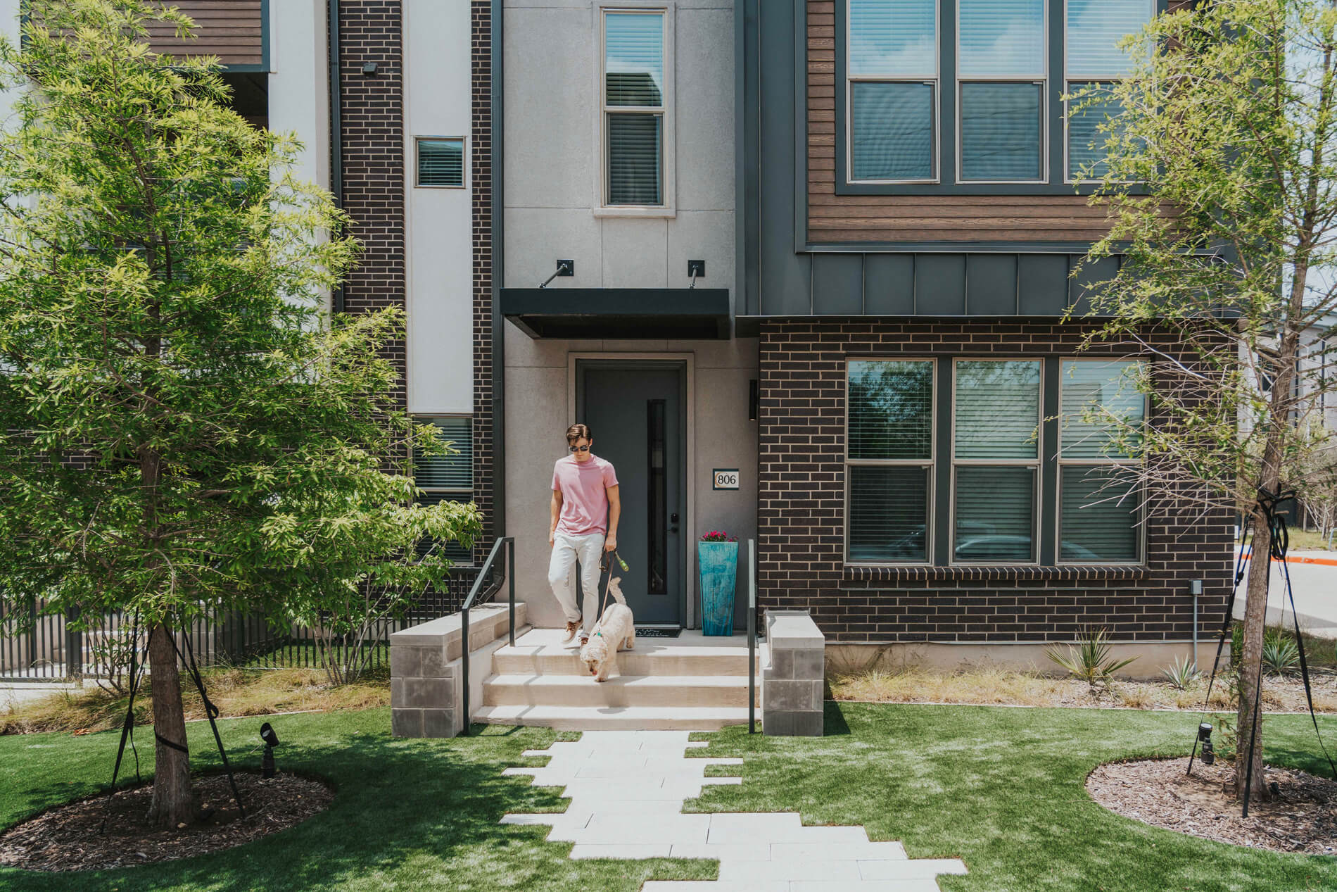 Villas At Fiori man walks dog outside building