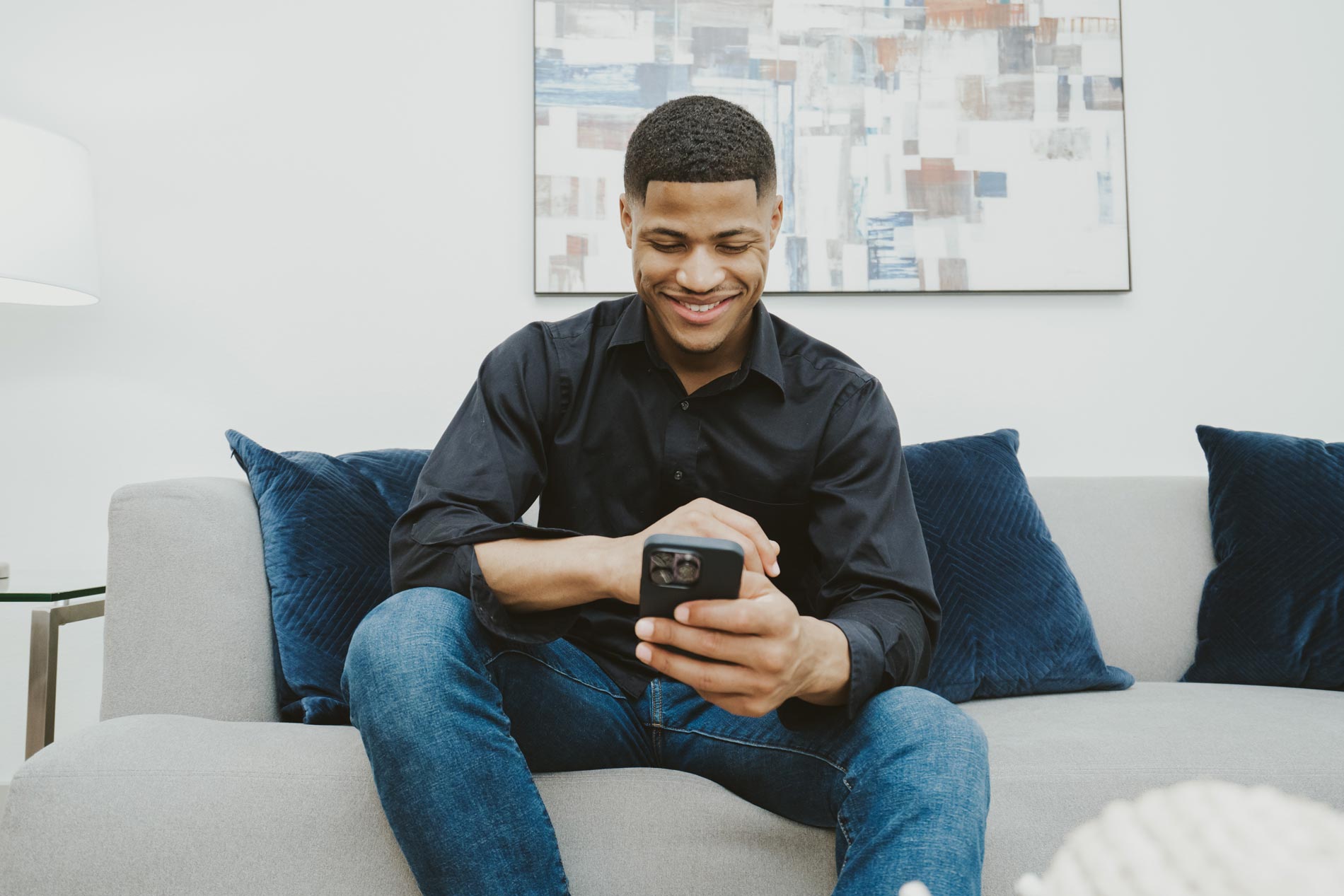 Vitruvian West Man on phone in living room