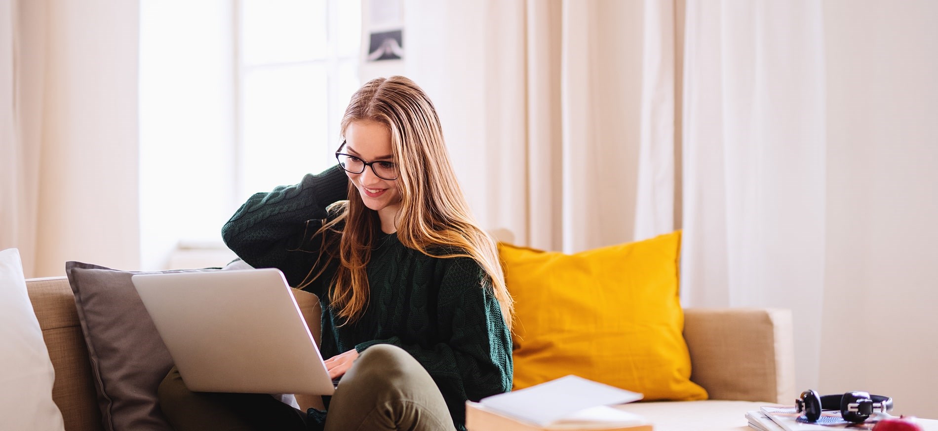 Happy woman working on laptop on couch