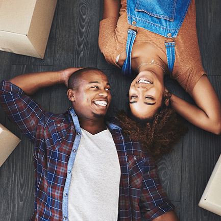 man and woman laying on floor between boxes